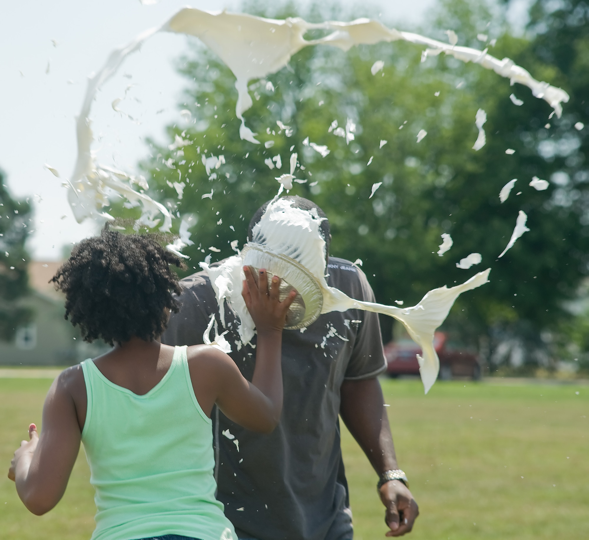 Eliza Gaithe throws a pie at science teacher Dr. Charles Konadu-Adjei during Positive Behavior Support Day June 14, 2011, at Dover Schools, Dover Air Force Base, Del. All students were invited to join in the day's activities because of their exemplary behavior through out the school year. (U.S. Air Force photo by Adrian Rowan)
