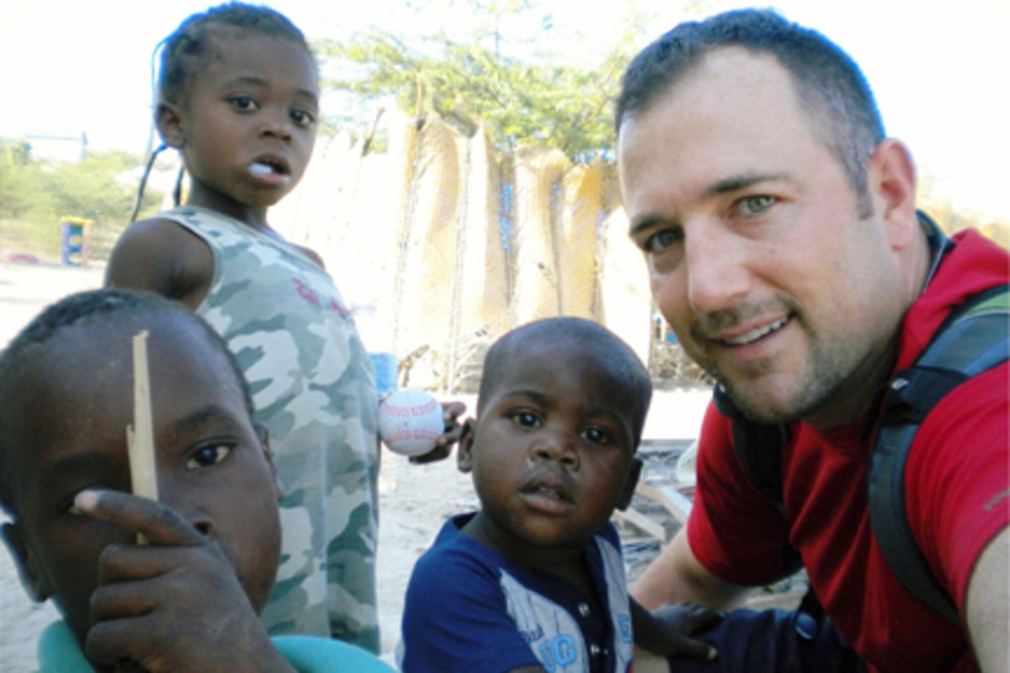 GRISSOM AIR RESERVE BASE, Ind., -- Master Sgt. Brad Wiedeman, Air Force Reserve Command recruiter, poses with Haitian children during a missionary trip to assist earthquake victims. (U.S. Air Force photo)
