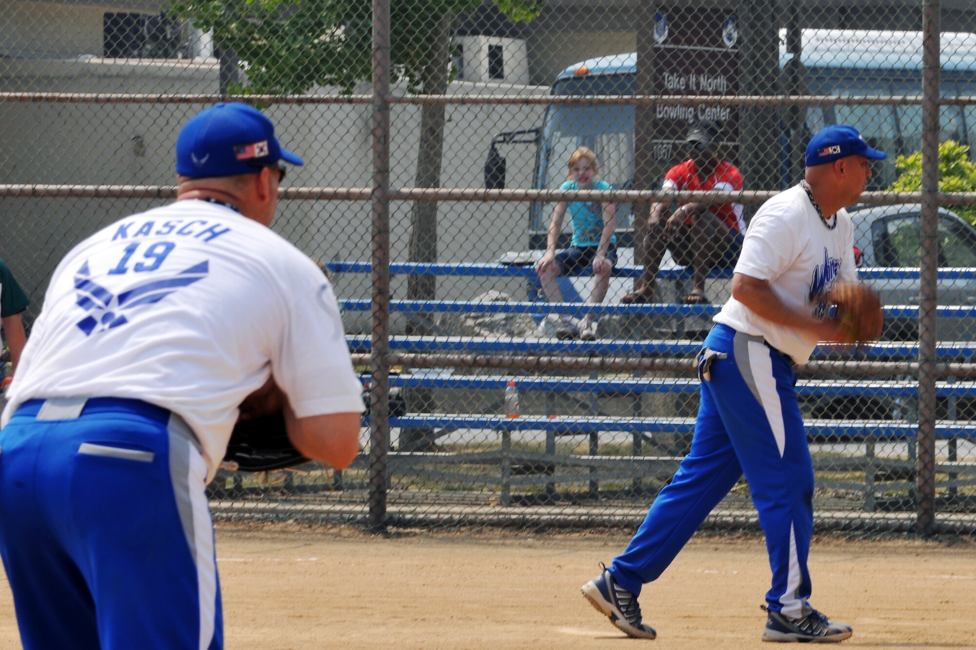 KUNSAN AIR BASE, Republic of Korea -- Master Sgt. James Kasch, 8th Communications Squadron communications security manager, waits as Tech. Sgt. Larry McEntire, from the 8th Aircraft Maintenance Squadron and team coach, gets ready to pitch the ball during a game of softball against the U.S. Army Garrison’s softball team here June 12. The two teams played three games against each other, Kunsan winning a series of 3-1. (U.S. Air Force photo/Senior Airman Brittany Y. Bateman)