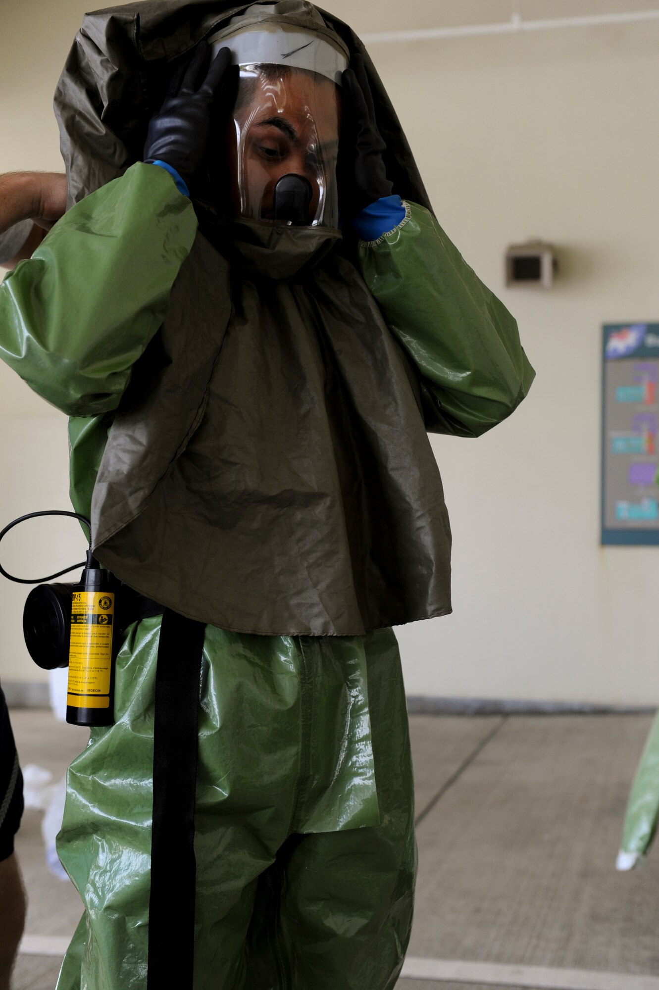 An Airman from the 18th Medical Group dons personal protective equipment during training for chemical, biological and nuclear decontamination on Kadena Air Base, Japan, June 9. During the training, teams were timed on their response to a simulated contamination emergency to assess the life-saving capabilities of the wing. (U.S. Air Force photo/ Airman 1st Class Brooke Beers) 