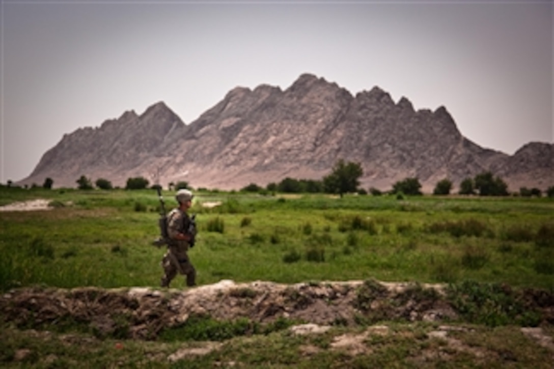 A U.S. Army soldier with Delta Company, 1st Battalion, 22nd Infantry Regiment, 1st Brigade Combat Team, 4th Infantry Division, walks through a valley during a patrol near Malajat, in Kandahar province, Afghanistan, on June 4, 2011.  