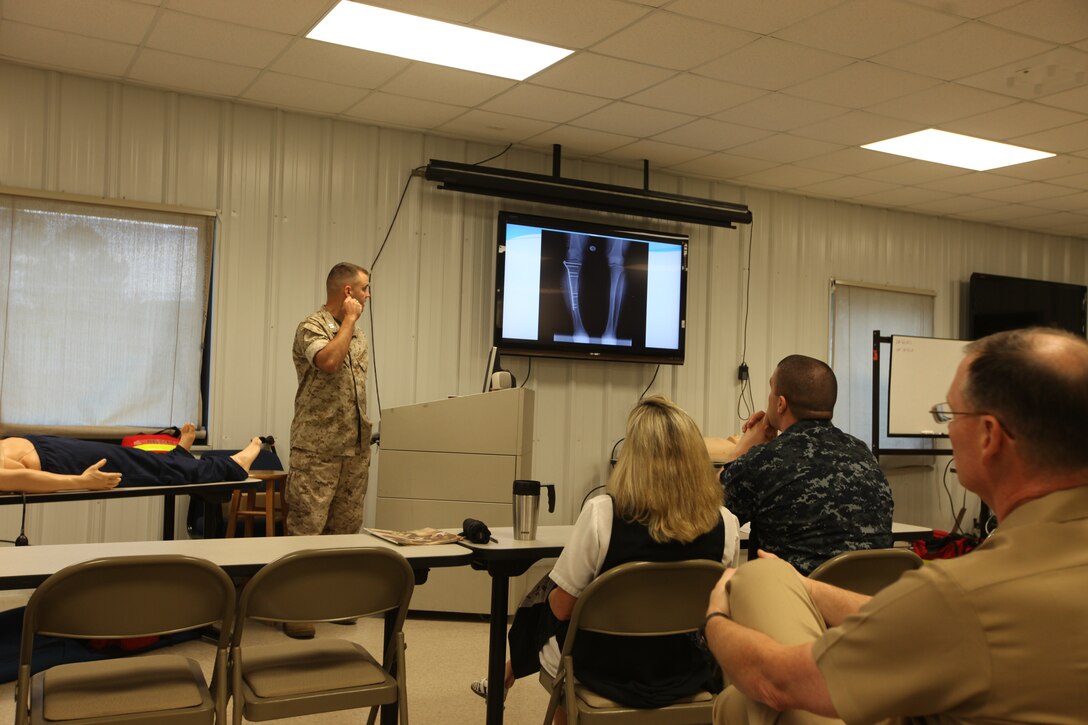 Capt. Matthew Kutilek speaks to Naval Hospital Camp Lejeune medical staff while explaining his recent surgery at the Chief Westfield building on the NHCL campus aboard Marine Corps Base Camp Lejeune. Kutilek has undergone 10 surgeries, attended multiple physical therapy and pain management appointments since his right leg was struck by an enemy sniper’s round on March 5, 2010 in the Helmand province, Afghanistan.