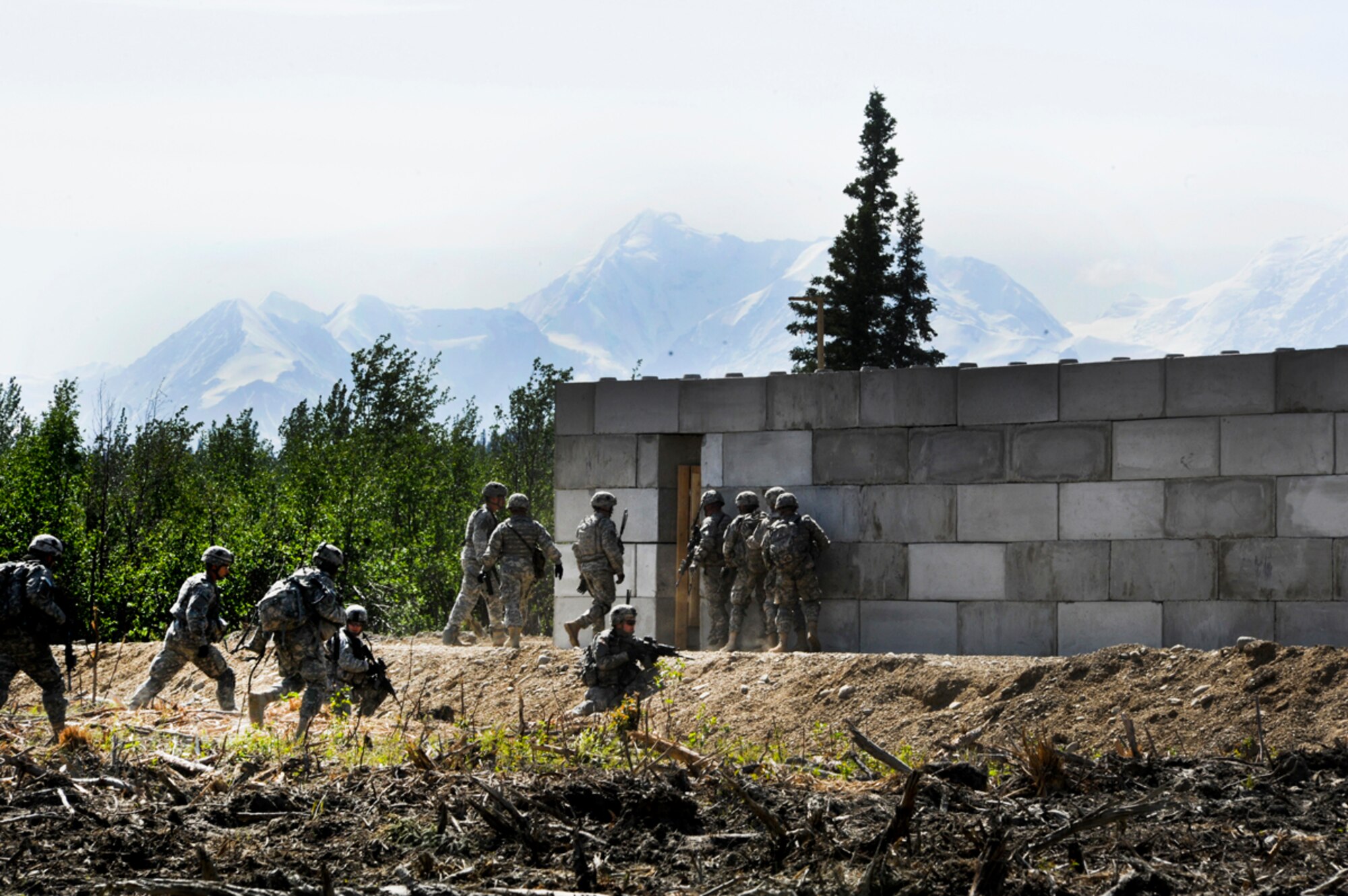 Paratroopers of Blackfoot Company, 1st Battalion (Airborne), 501st Infantry Regiment, enter a simulated improvised explosive device factory during a platoon-level live fire exercise at Donnelly Training Area, June 7. (Photo by Airman 1st Class Jack Sanders/JBER PA)