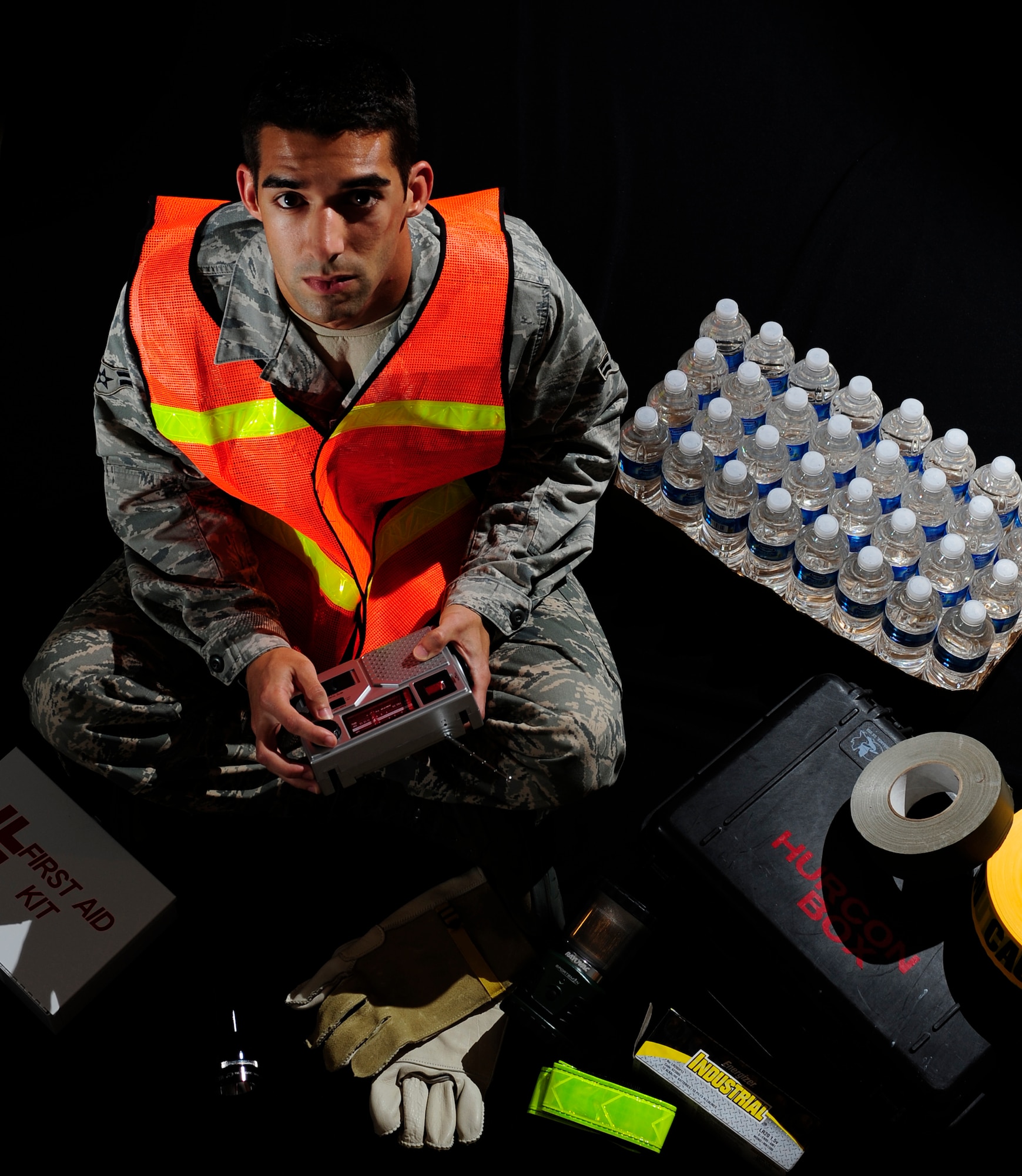 U.S. Air Force Airman 1st Class Eric Avellar, 1st Special Operations Comptroller Squadron, sits among some of the items needed for a hurricane kit, Hurlburt Field, Fla., June 16, 2011. Building a disaster kit can be useful whether you're riding out a storm or evacuating and need to grab important items in a hurry. (U.S. Air Force photo by Staff Sgt. Julianne M. Showalter/Released)
