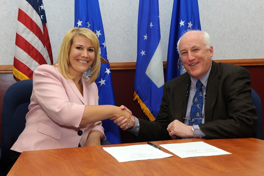 Angie Tymofichuk, Ogden Air Logistics Center director of the Engineering Directorate, and Tim Ameel, chairman of the Mechanical Engineering Department at the University of Utah, shake hands after signing an Educational Partnership Agreement on June 13 in a conference room at Hill Air Force Base. The agreement paves the way for upper level graduate students to do research with the base and work on state-of-the-art problems which the Air Force and the base have before them. (U.S. Air Force photo by Alex Lloyd)