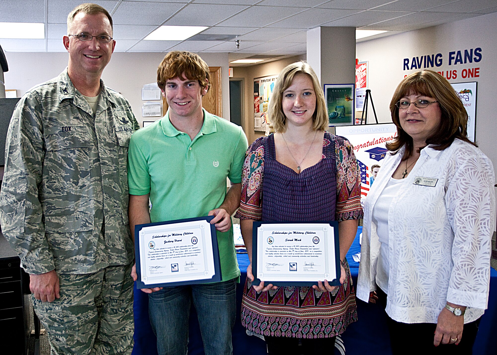 Col. Scott Fox, 90th Missile Wing vice commander, and Kathy Beatty, Warren commissary, present Scholarship for Military Children awards to Zachary Heard and Sarah Mock at Warren’s Commissary June 9. (U.S. Air Force photo by Matt Bilden)