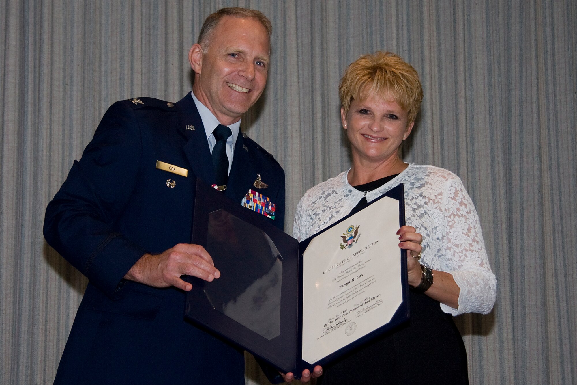 GRISSOM AIR RESERVE BASE, Ind. -- Col. Tim Cox and his wife Tanya pose with a certificate of appreciation for Mrs. Cox from Gen. Norton Schwartz, Air Force chief of staff, and Lt. Gen. Charles Stenner, Air Force Reserve Command commander, during the colonel's retirement ceremony here May 14. Colonel Cox retired from the Air Force Reserve as the 434th Air Refueling Wing vice commander after 30 years of military service. (U.S. Air Force photo/Tech. Sgt. Mark R. W. Orders-Woempner) 
