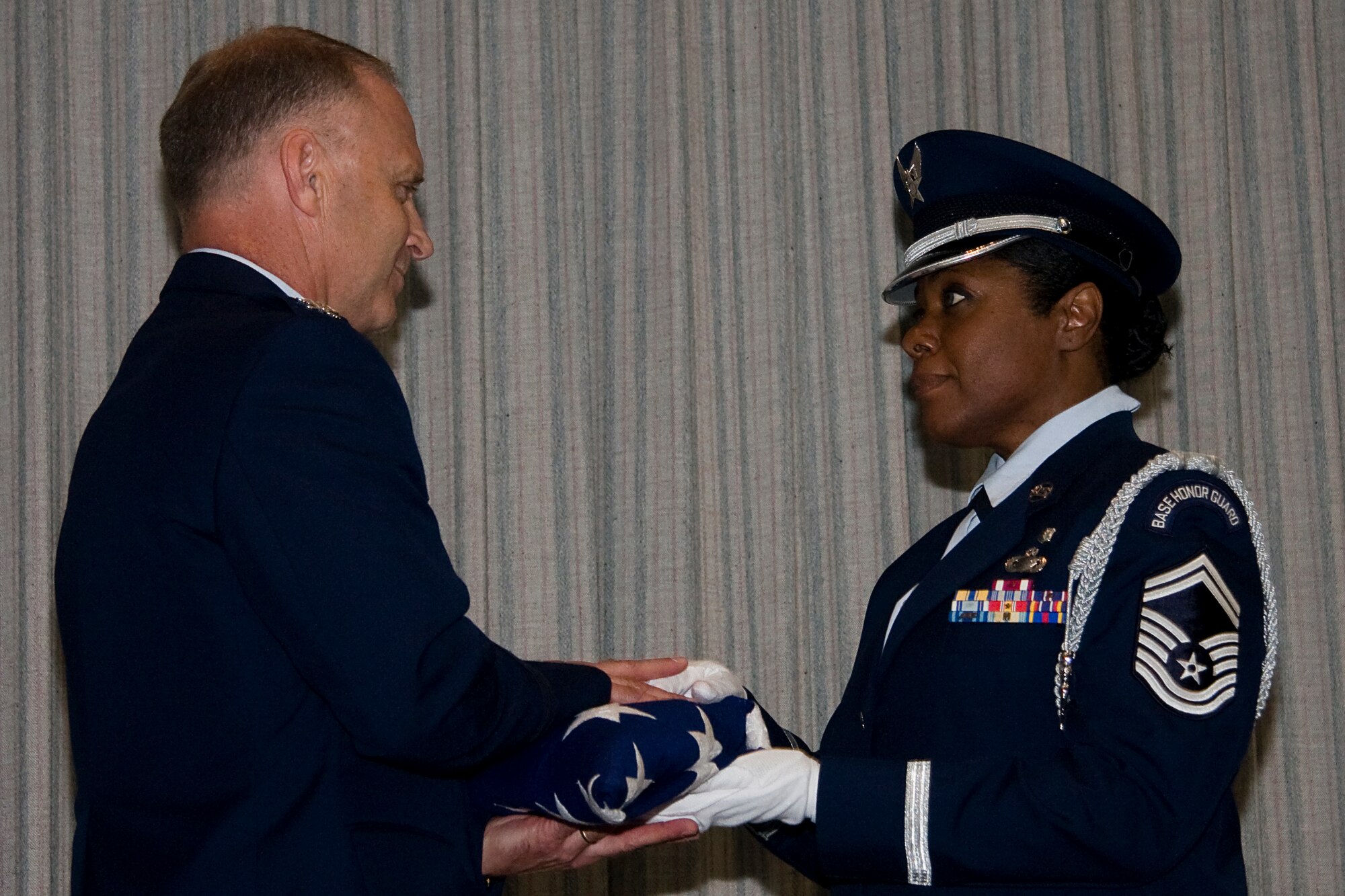 GRISSOM AIR RESERVE BASE, Ind. -- Senior Master Sgt. Linda Mason-Wilson, Grissom Air Reserve Base Honor Guard, presents Col. Tim Cox, 434th Air Refueling Wing vice commander, with an American Flag during his retirement ceremony held here May 14. Sergeant Mason-Wilson was the 74th Air Refueling Squadron first sergeant when Colonel Cox was the unit's commander. The colonel retired from the Air Force Reserve after 30 years of military service and thanked Sergeant Mason-Wilson for her help and guidance when he first became a squadron commander. (U.S. Air Force photo/Tech. Sgt. Mark R. W. Orders-Woempner) 
