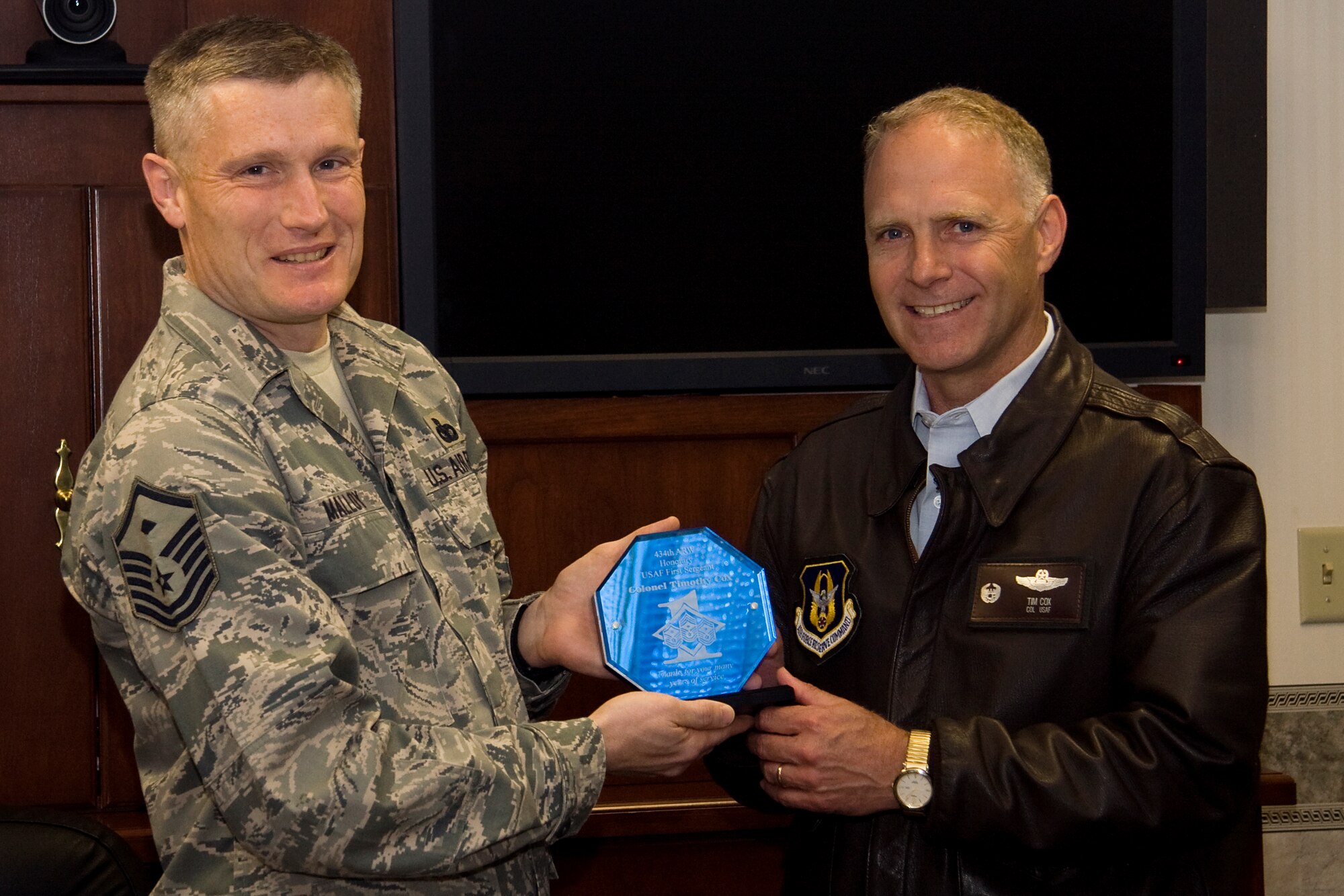 GRISSOM AIR RESERVE BASE, Ind. -- Master Sgt. James Malloy, 434th Communications Squadron first sergeant, presents Col. Tim Cox, 434th Air Refueling Wing vice commander, with a plaque recognizing the colonel as an honorary first sergeant May 13. Sergeant Malloy, who is also the Grissom First Sergeant Council president, presented the plaque to Colonel Cox the day before his retirement ceremony. (U.S. Air Force photo/Tech. Sgt. Mark R. W. Orders-Woempner) 
