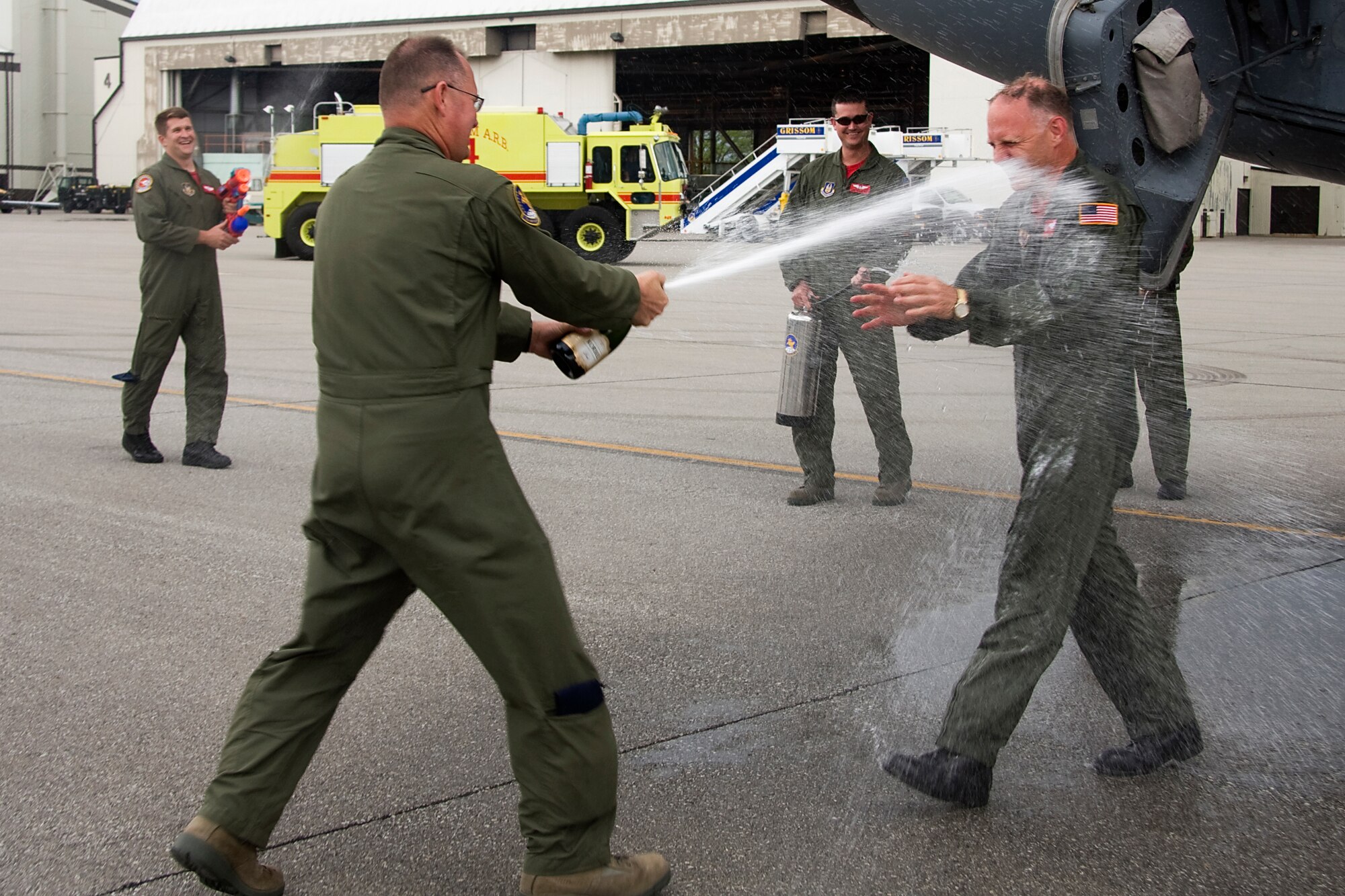 GRISSOM AIR RESERVE BASE, Ind. -- Master Sgt. Scott Ward blasts Col. Tim Cox in the face with a sparkling beverage after the colonel completed his last flight as an Air Force Reserve KC-135R Stratotanker pilot May 13. Also pictured are Maj. Mike Hoke, 74th Air Refueling Squadron chief pilot, and Staff Sgt. Rob Faurot, 74th ARS in-flight refueling technician. Colonel Cox retired from the Air Force Reserve as the 434th Air Refueling Wing vice commander after 30 years of military service. Sergeant Ward is an in-flight refueling evaluator with the 72nd ARS. (U.S. Air Force photo/Tech. Sgt. Mark R. W. Orders-Woempner) 
