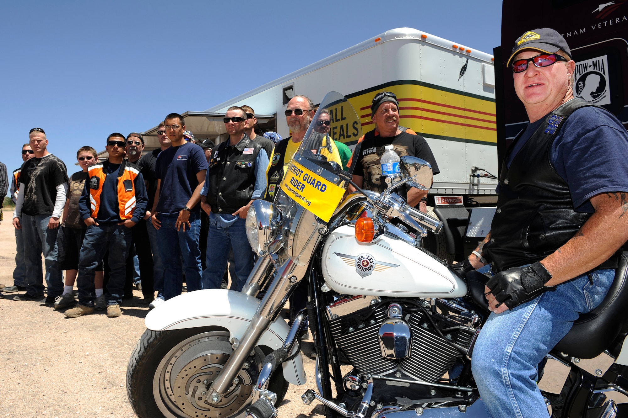Local motorcyclists, including government employees, former and current military members and civilians, pose by the traveling Vietnam Memorial Wall June 7, 2011, in Colorado Springs, Colo. The riders joined members of the Patriot Guard Riders to escort the display as it traveled to Fort Carson, Colo., for a six-day display. (U.S. Air Force photo/ Dennis Rogers) 
