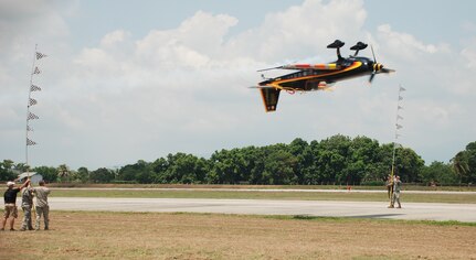 Aerial stunt performer Patty Wagstaff cuts ribbon while flying inverted as U.S. and Honduran military and civilians assist at an air show June 12, 2011, at Colonel Armando Escalon Espinal Air Base, Honduras. This annual event drew more than 10,000 spectators, raised money for a local civilian hospital and bolstered friendships between the military and civilian aviation community of the U.S. and Honduras. (U.S. Air Force photo/Capt. David McCain)