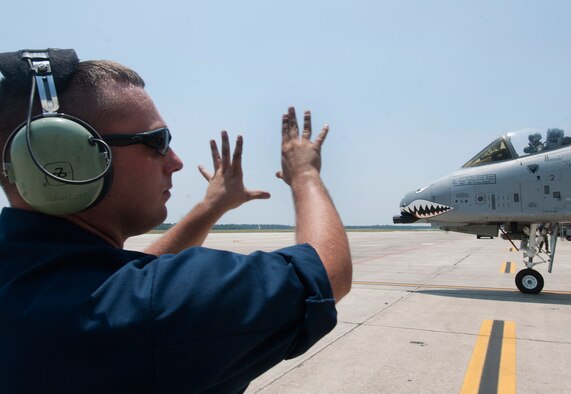 U.S. Air Force Senior Airman Brendan Tuttle, 74th Aircraft Maintenance Unit crew chief, launches an A-10C Thunderbolt II during a phase II operational readiness exercise flying surge at Moody Air Force Base, Ga., June 15. As the aircraft made its way out of the hangar, Airman Tuttle insured it was safe to taxi. (U.S. Air Force photo by Senior Airman Benjamin Wiseman/Released)