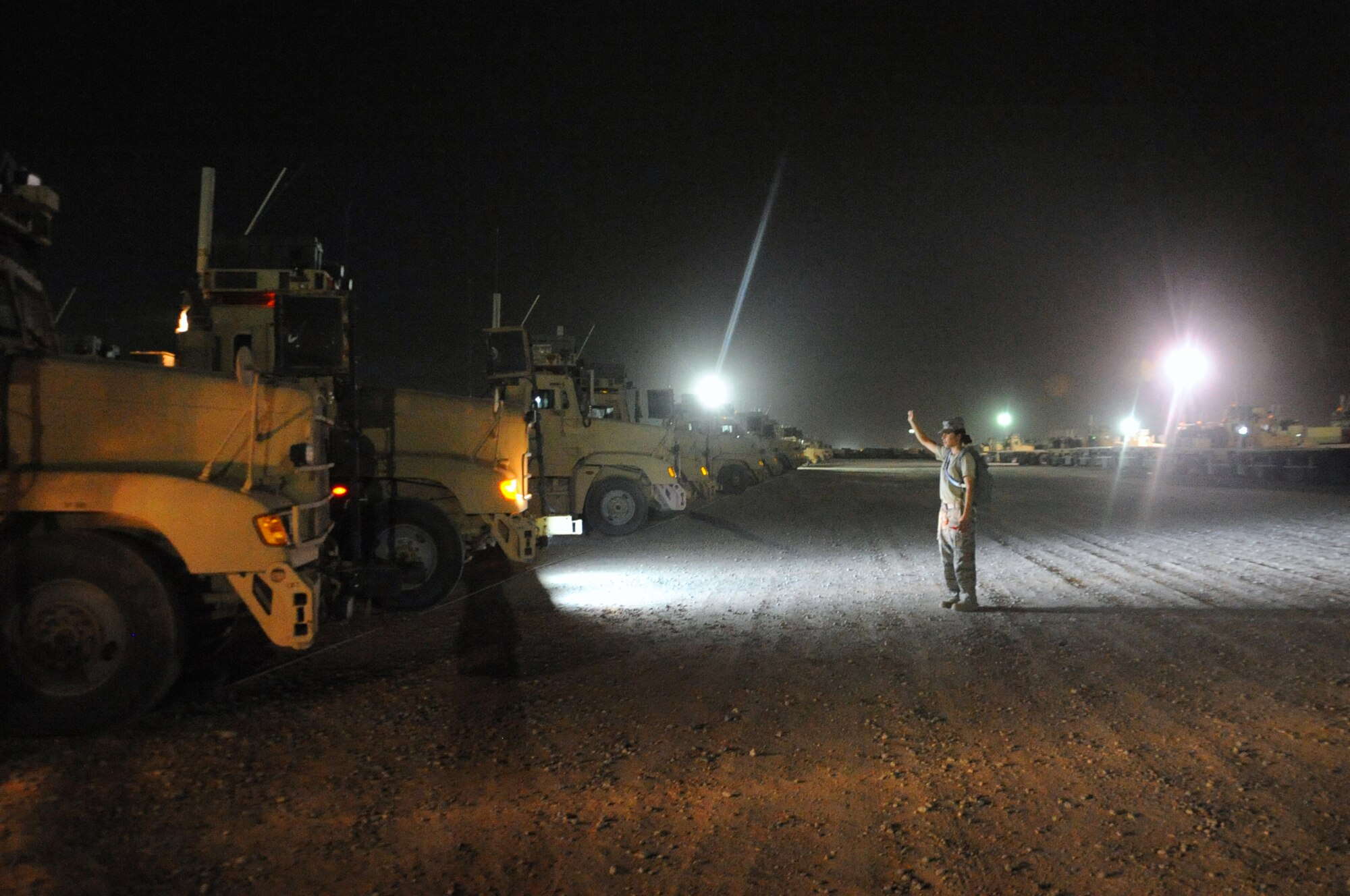 A vehicle operator assigned to the 387th Expeditionary Logistics Readiness Squadron acts as a ground guide for her driver during hours of darkness upon completion of a local convoy mission. There are two Airmen in each truck, a truck commander (TC) and the driver. The TC will always guide the driver in and out of designated areas. (U.S. Air Force photo by Senior Airman Cynthia Spalding)
