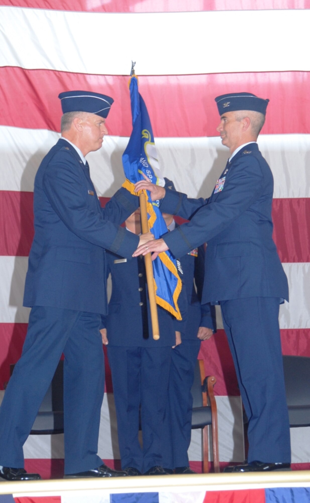 U.S. Air Force Brig. Gen. Joseph Balskus, left, passes the 101st Air and Space Operations Group (101st AOG) flag to Col. Thomas Cucchi during a change of command ceremony held here June 11, 2011. This was the very first change of command ceremony for the 101st AOG, which was officially activated July 1, 2009. (U.S. Air Force photo by Maj. Steve Burke/Released)