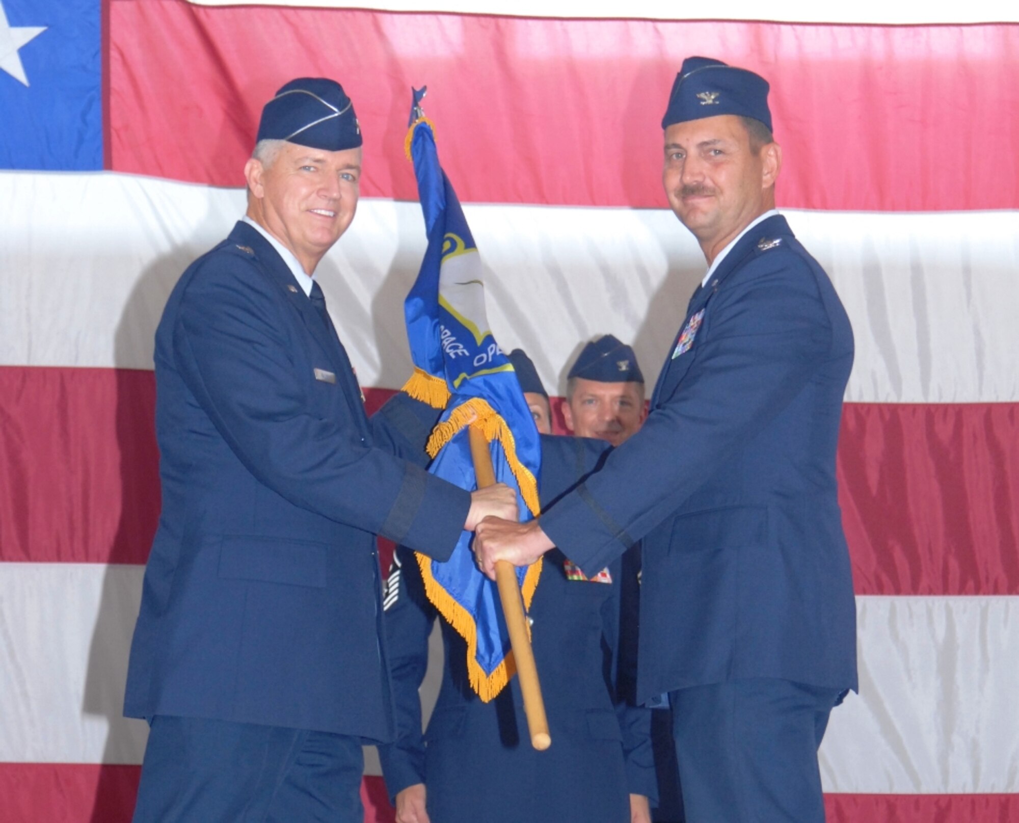U.S. Air Force Brig. Gen. Joseph Balskus, left, receives the 101st Air & Space Operations Group (101st AOG) flag from Col. Scott Barberides as he relinquishes his command during a change of command ceremony held here June 11,2011. This was the very first change of command ceremony for the 101st AOG, which was officially activated July 1, 2009. Colonel Barberides served as the first commander of the 101st AOG. (U.S. Air Force photo by Maj. Steve Burke/Released)