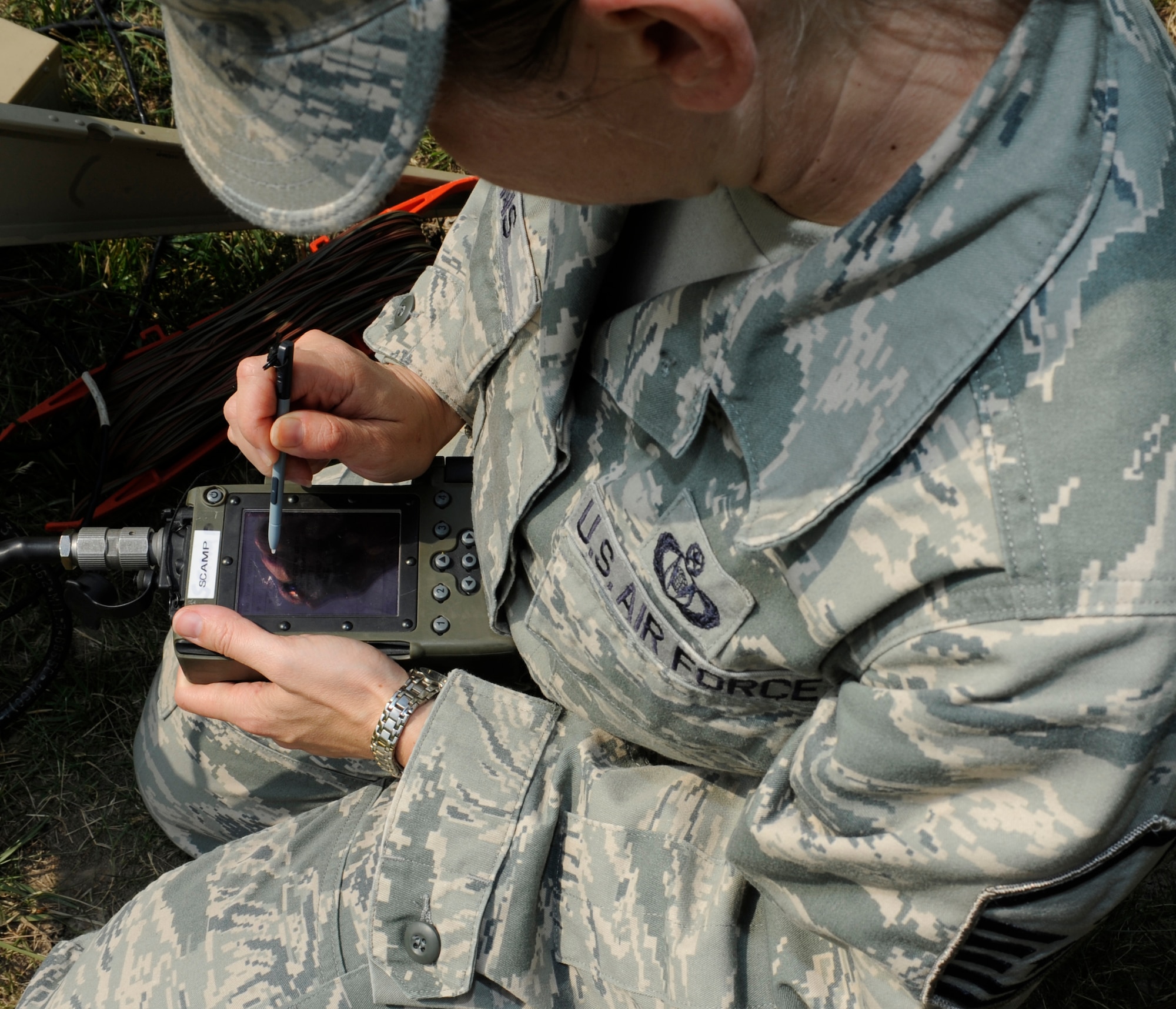 WHITEMAN AIR FORCE BASE, Mo. -- Master Sgt. Jennifer Lyons, 509th Bomb Wing command post NCO in charge of command and control, uploads a communication security code to the receiver of the Single Channel Anti-Jam Man Potable (SCAMP) terminal here June 10. The SCAMP is used to receive emergency activation messages from higher headquarters and direct base operations. (U.S. Air Force photo by Senior Airman Alexandra M. Boutte) 