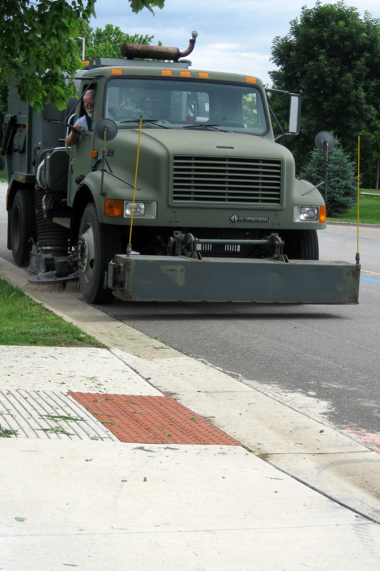 GRISSOM AIR RESERVE BASE, Ind. -- Robert Hopkins, an equipment operator with Data Monitor Systems, Inc., sweeps the curbs and street heading south on Warrior Avenue.. Keeping Grissom looking its best requires a team of dedicated workers. (U.S. Air Force photo/Tech. Sgt. Douglas Hays)
