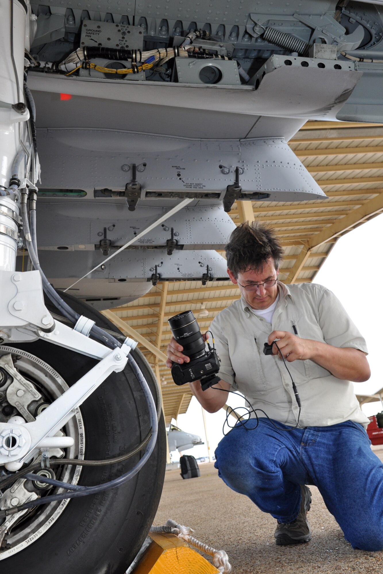 Danny Coremans, an aircraft photographer from Antwerpen, Belgium, uses a remote digital view finder with an LCD display to capture images of an A-10 Thunderbolt II for his new book during a visit to Barksdale Air Force Base, La., June 15, 2011. Mr. Coremans, who has traveled the world to photograph different military aircraft, has published eight books worldwide, with his ninth, a book about the Lockheed F-104 Starfighter, scheduled to be released later this year. Mr. Coremans is a former F-16 crew chief for the Belgium air force. He is currently working on a book about the A-10 Thunderbolt, which is scheduled for release in 2012. (U.S. Air Force photo/Tech. Sgt. Jeff Walston)            