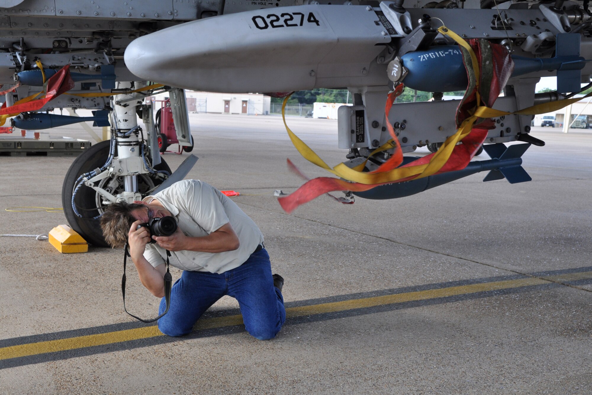 Danny Coremans, an aircraft photographer from Antwerpen, Belgium, gets a shot of BDU-33 practice bombs loaded onto an A-10 Thunderbolt II for his new book during a visit to Barksdale Air Force Base, La., June 15, 2011. Mr. Coremans, who has traveled the world to photograph different military aircraft, has published eight books worldwide, with his ninth, a book about the Lockheed F-104 Starfighter, scheduled to be released later this year. Mr. Coremans is a former F-16 crew chief for the Belgium air force. He is currently working on a book about the A-10 Thunderbolt, which is scheduled for release in 2012. (U.S. Air Force photo/Tech. Sgt. Jeff Walston)            