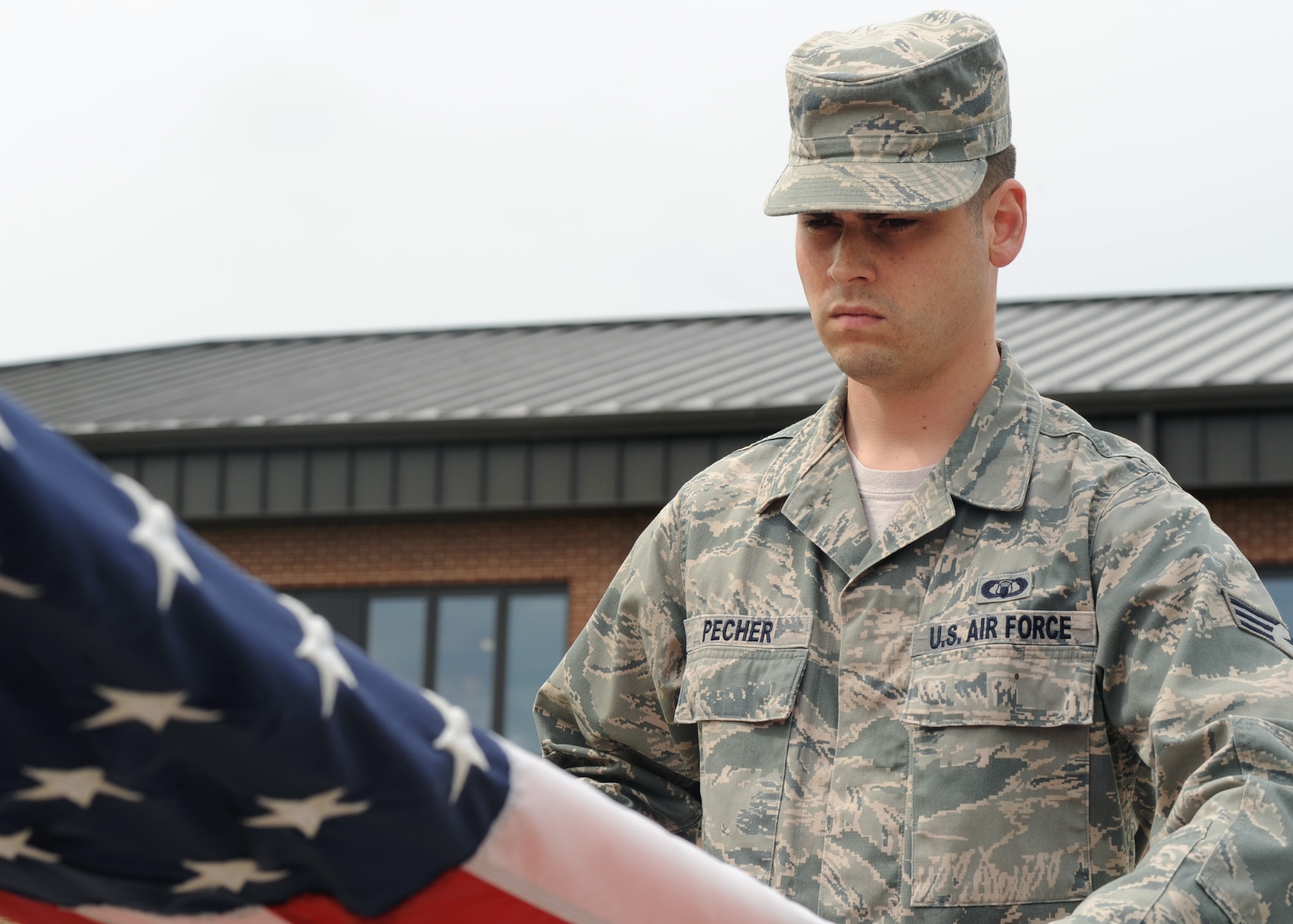 Senior Airman Michael Pecher, 319th Operations Support Squadron, folds the flag during the Retreat Ceremony June 10, 2011 on Grand Forks Air Base, N.D.  The base will have different Squadrons perform retreat until the Friday before Labor Day.  The Retreat Ceremony serves a twofold purpose – it both signals the end of the duty day and serves as a ceremony for paying respect to the flag. (U.S. Air Force photo by Senior Airman Amber Bennett)