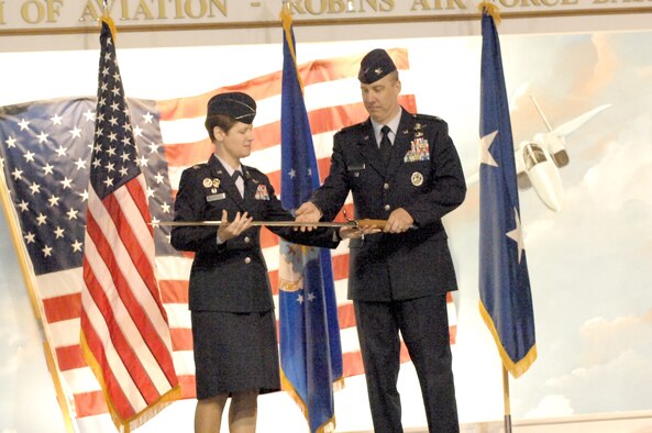 Col. Theresa Giorlando, presents Col. Joseph Scherrer, new 689th Combat Communications Wing commander, with a sword after relinquishing command of the wing. U. S. Air Force photo by Ray Crayton