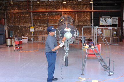 Johnny Esquivel,12th Flying Training Wing Maintenance Division, Tapes and glues all the openings on a T-38 Talon aircraft from Laughlin Air Force Base June 7. The aircraft will then be placed in the media blast booth at Randolph Air Force Base for paint stripping. (U.S. Air Force photo/Rich McFadden) (released)
