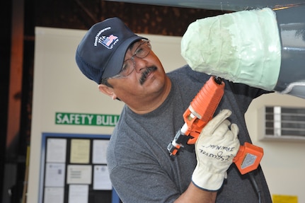 Johnny Esquivel,12th Flying Training Wing Maintenance Division, Tapes and glues all the openings on a T-38 Talon aircraft from Laughlin Air Force Base June 7. The aircraft will then be placed in the media blast booth at Randolph Air Force Base for paint stripping. (U.S. Air Force photo/Rich McFadden) (released)
