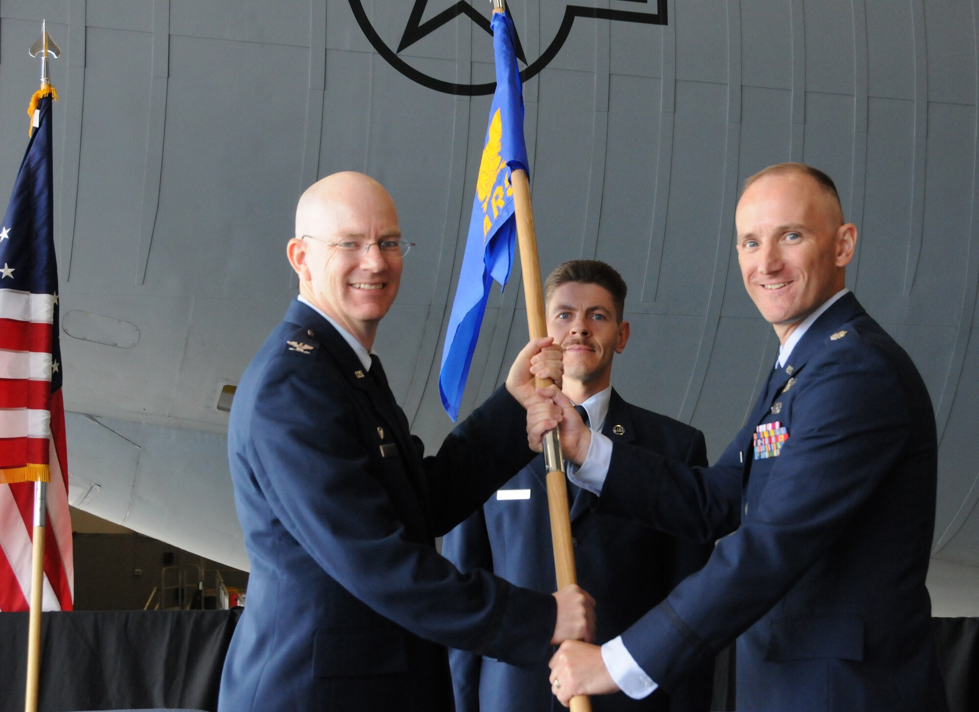 Colonel Thomas J. Riney (left), commander 22d Operations Group, McConnel Air Force Base, Kansas presents the 64th Air Refueling Squadron's guidon to Lieutenant Colonel Ryan R. Samuelson symbolizing the 64th ARS's change of command from and  Lt. Col. Christopher D. Leist to Lt. Col. Samuelson, Pease Air National Guard Base, New Hampshire, June 2, 2011.  Master Sergeant Jeffrey J. Heik, 64th ARS First Sergeant looks on. The 64th ARS is the first KC-135 Air National Guard Active Associate Squadron under the Air Force’s concept of Total Force Integration.  (U.S. Air Force photo/Staff Sgt. Curtis J. Lenz)