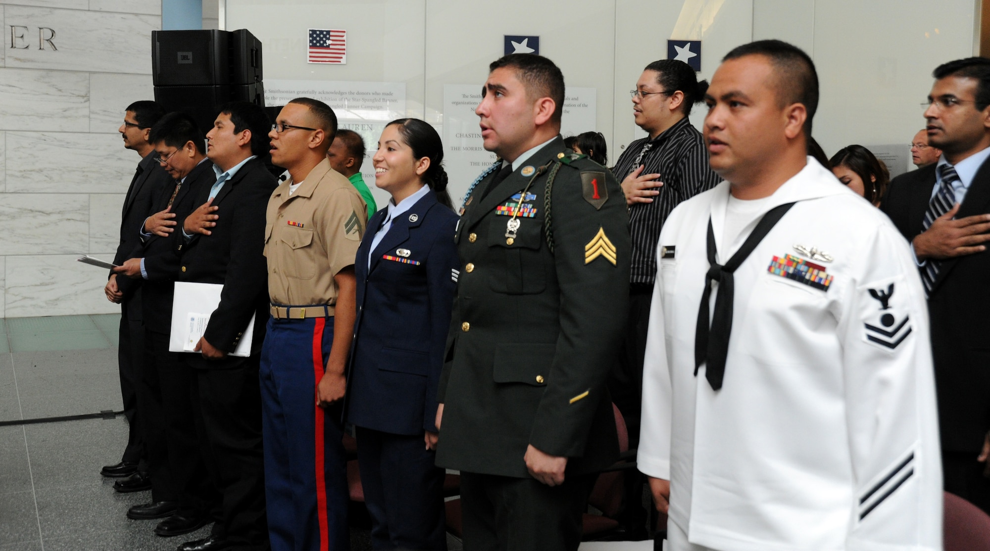 WASHINGTON – Senior Airman Deborah Vives, 11th Comptroller Squadron customer service technician, proudly recites the Pledge of Allegiance with a group of 19 other new citizens during a naturalization ceremony at the Smithsonian National Museum of American History here June 14. This naturalization ceremony was in celebration of Flag Day 2011 and featured guest speaker Gerda Weissmann Klein, Holocaust survivor and founder of Citizenship Counts. (U.S. Air Force photo by Airman 1st Class Bahja J. Jones) 