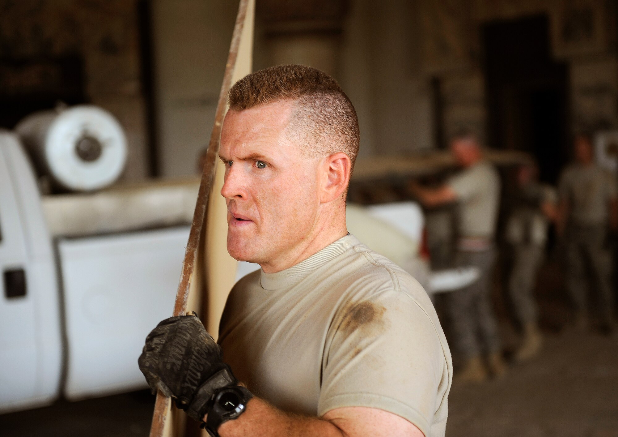 BAGHDAD, Iraq -- Senior Master Sgt. Jeff Gideon, 447th Air Expeditionary Group force support, hauls out plywood inside Victory Over America Palace during the last day of a three-day cleanup effort June 11. The San Antonio, Texas, native is deployed from Lackland Air Force Base, Texas. (U.S. Air Force/Tech. Sgt. Jason Lake)  