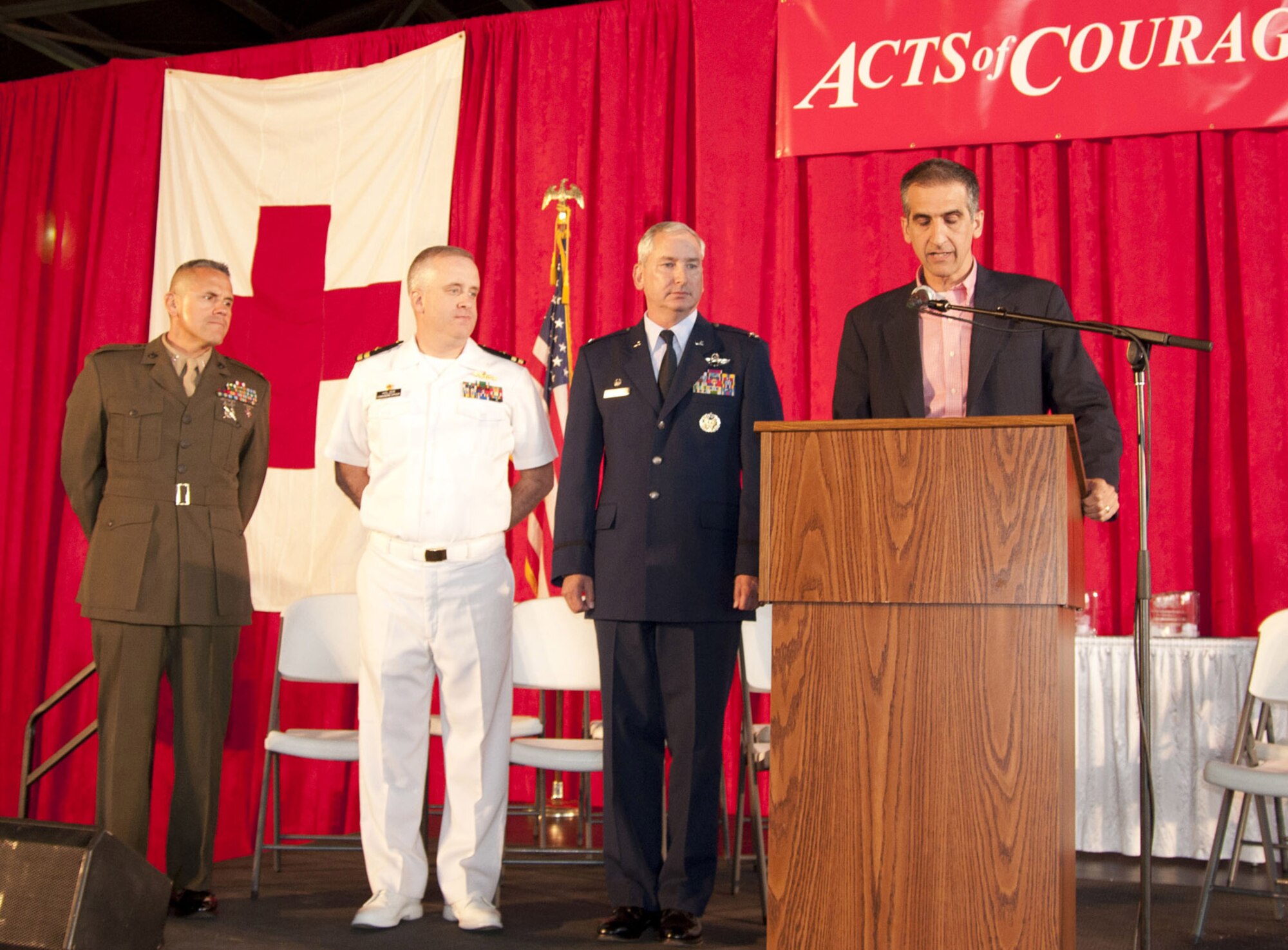 VIENNA, Ohio -- U.S. Marine CWO4 Emiliano Deleon, Naval Commanding officer Lt. John Holzer and Air Force Reserve Col. Fritz Linsenmeyer stand before hundreds of guests at the first annual American Red Cross Acts of Courage dinner banquet June 14 at Winner Aviation.  The Marine, Sailor and Airman representing their respective Youngstown Air Reserve Station units received trophies along with several other civilian recipients. 