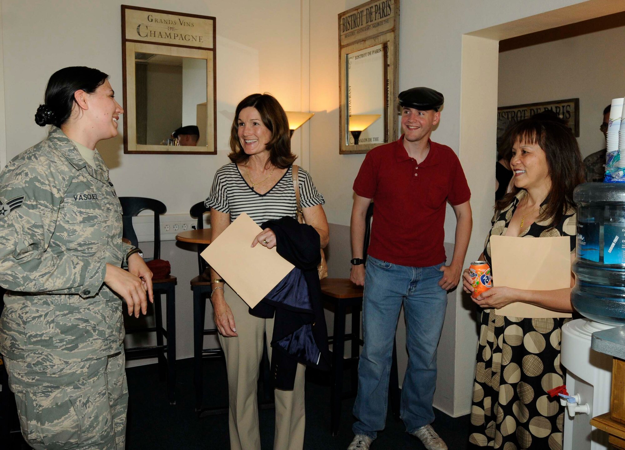 Betty Welsh (middle), wife of Gen. Mark A. Welsh III, U.S. Air Forces in Europe commander, and Mary Williamson (right), wife of Chief Master Sgt. David W. Williamson, USAFE command chief, speaks with volunteer, Senior Airman Alysia Vasquez about Club 7 operations as part of their official immersion with the 86th Airlift Wing, Ramstein Air Base, Germany, June 15. Though the spouses are familiar with the base due to their residence here, this visit offered the unique opportunity to see new programs geared at taking care of Airmen and their families and meet the individuals that make it all happen. (U.S. Air Force photo by Airman 1st Class Kendra Alba) 