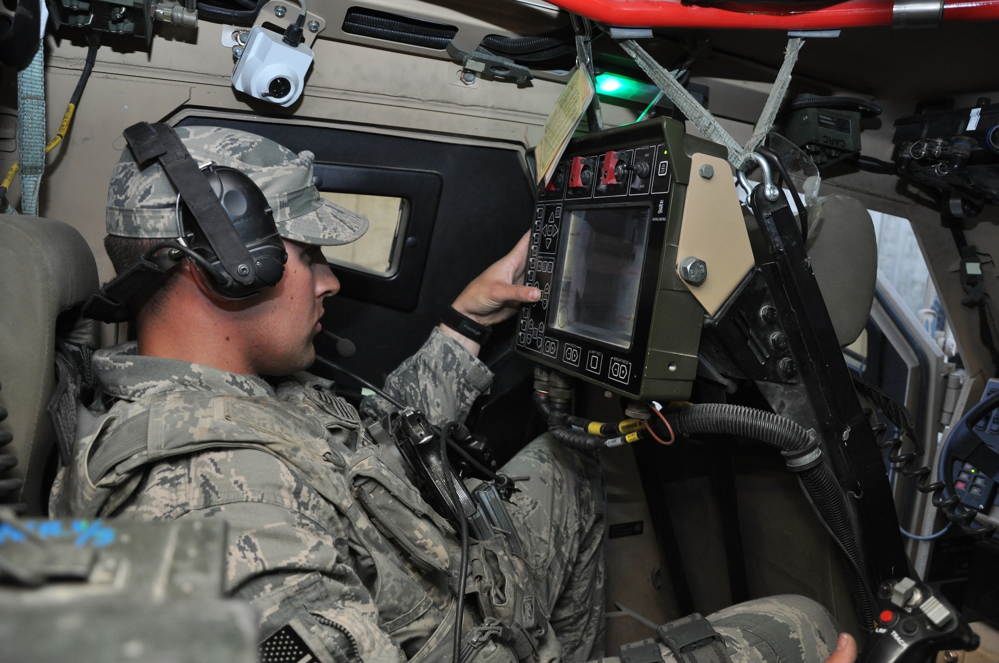 BAGRAM AIRFIELD, Afghanistan – Senior Airman Tyler McEuin, 455th Expeditionary Security Forces Squadron Quick Response Team Common Remotely Operated Weapon Station operator, adjusts his video monitor prior to setting out on a mission here June 6. The CROWS allows Airman McEuin to operate a large caliber machine gun using a video screen and joystick from the safety of inside an armored assault vehicle. (U.S. Air Force photo by Staff Sgt. John Wright)