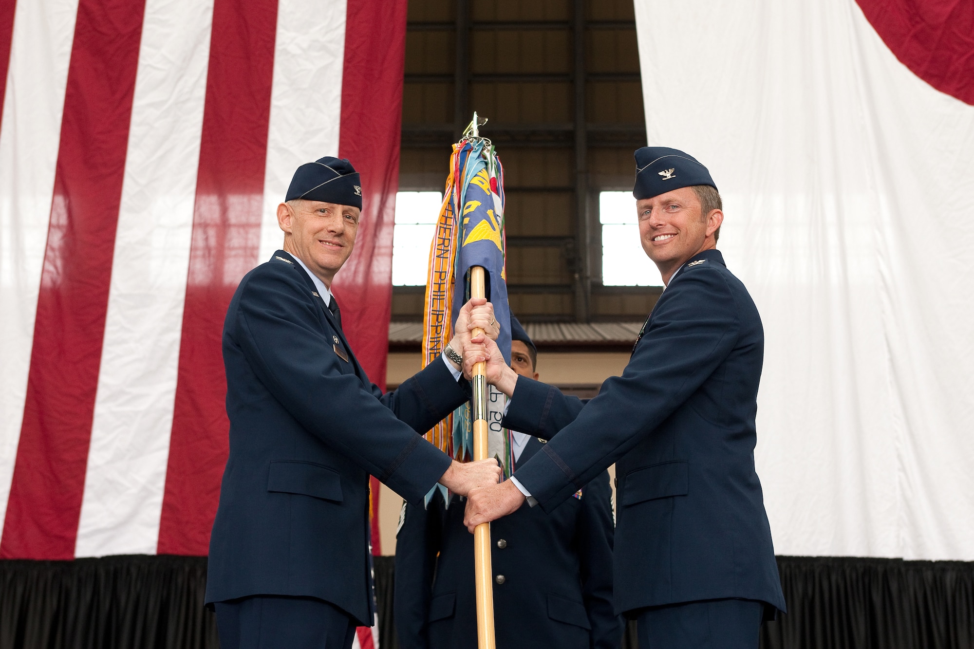 YOKOTA AIR BASE, Japan -- Col. Otto Feather, 374th Airlift Wing commander (left), passes the guidon to Col. David Gould II, incoming 374th Operations Group commander, during an assumption of command ceremony June 16, 2011, at Yokota Air Base, Japan. Colonel Gould was the former Director of Operations, Headquarters Air Force Operational Test and Evaluation Center, Kirtland Air Force Base, New Mexico. (U.S. Air Force photo/Osakabe Yasuo)
