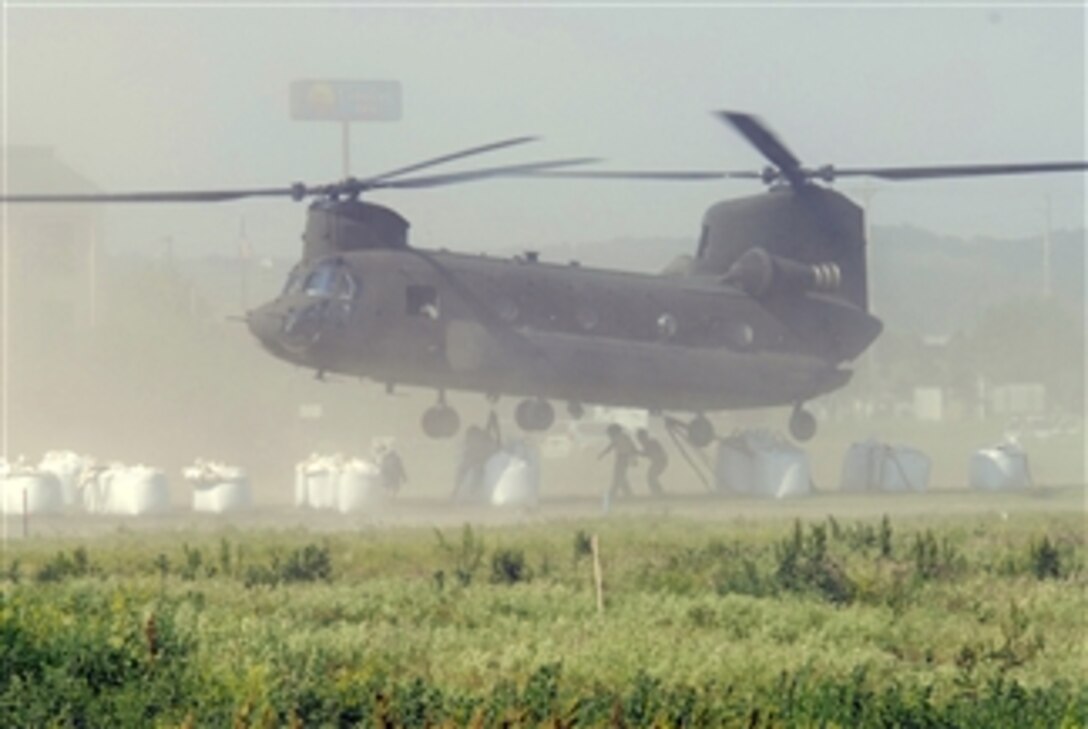 A CH-47 Chinook helicopter from the Illinois Army National Guard hooks on to two large sandbags that will be delivered to residents living along the flooded Missouri River in Iowa on June 8, 2011.  Additionally four UH-60 Black Hawk helicopters from the Minnesota and Iowa National Guard delivered sandbags to many other of the critical areas along the river.  Over 400 National Guard members were activated to provide support to communities along the Missouri River in danger of flooding.   