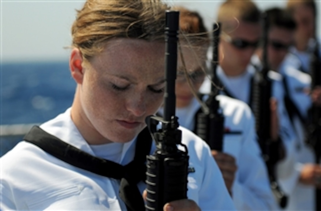 Sailors bow their heads for prayer during a burial at sea rehearsal aboard the guided-missile destroyer USS Truxtun (DDG 103) in the Atlantic Ocean on June 13, 2011.  The Truxtun is deployed as part of the George H.W. Bush Carrier Strike Group supporting maritime security operations and theater security cooperation efforts in the U.S. 6th Fleet areas of responsibility.  