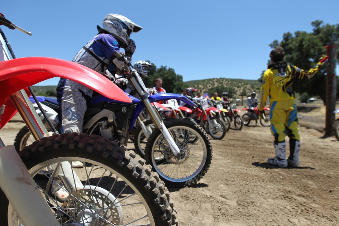 Ronnier Renner [right], an X-Games gold medalist explains the “attack position,” and how to properly handle a jump on a track, to a group of riders.::r::::n::