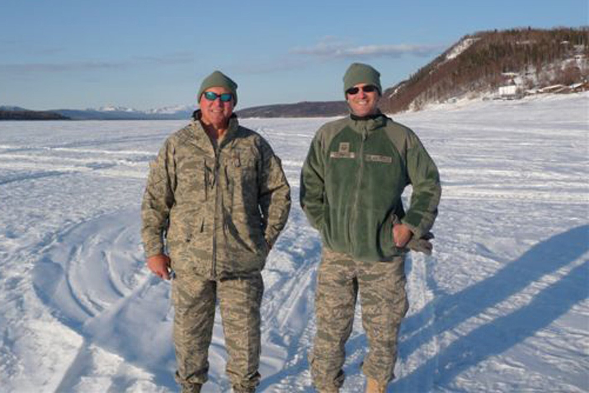 Maj. David Parker (left), 403rd Aeromedical Staging Squadron officer in charge of optometry, and Master Sgt. Matthew Leonard, 403rd ASTS optometric technician and NCO in charge of optometry, stand atop the frozen Yukon River outside the village of Ruby, Alaska, during their deployment for Operation Arctic Care. For this annual two-week mission, various military and government medical professionals travel to remote villages to treat native Alaskans with limited access to general health care. (Courtesy photo)