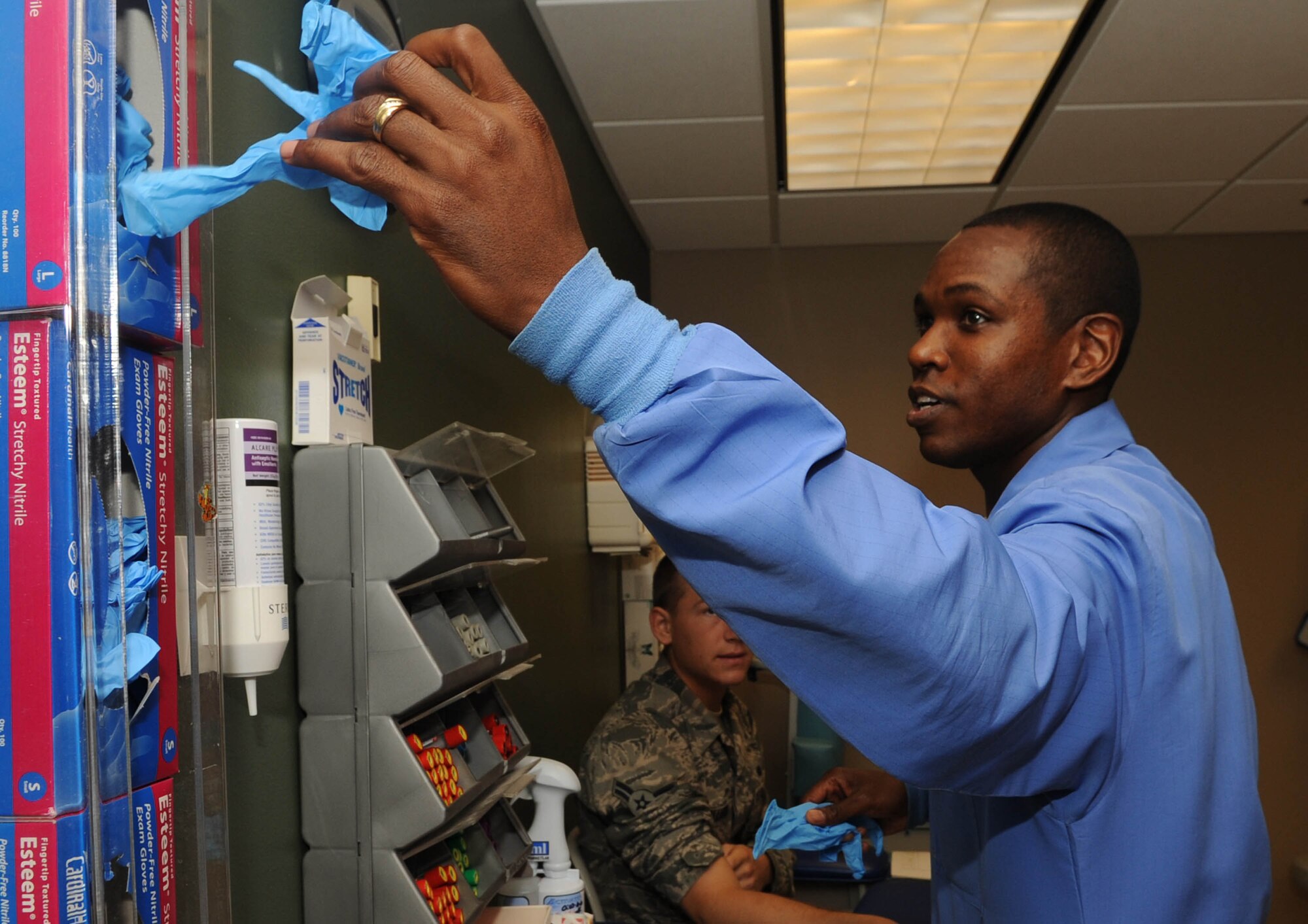 Staff Sgt. Terrance Raybon, 2nd Support Squadron, grabs a glove before collecting an airman's blood at the clinic on Barkdale Air Force Base, La., Jun 15. Blood tests are used to determine physiological and biochemical states, such as disease, mineral content, drug effectiveness and organ function. (U.S. Air Force photo/Senior Airman Kristin High)(RELEASED)