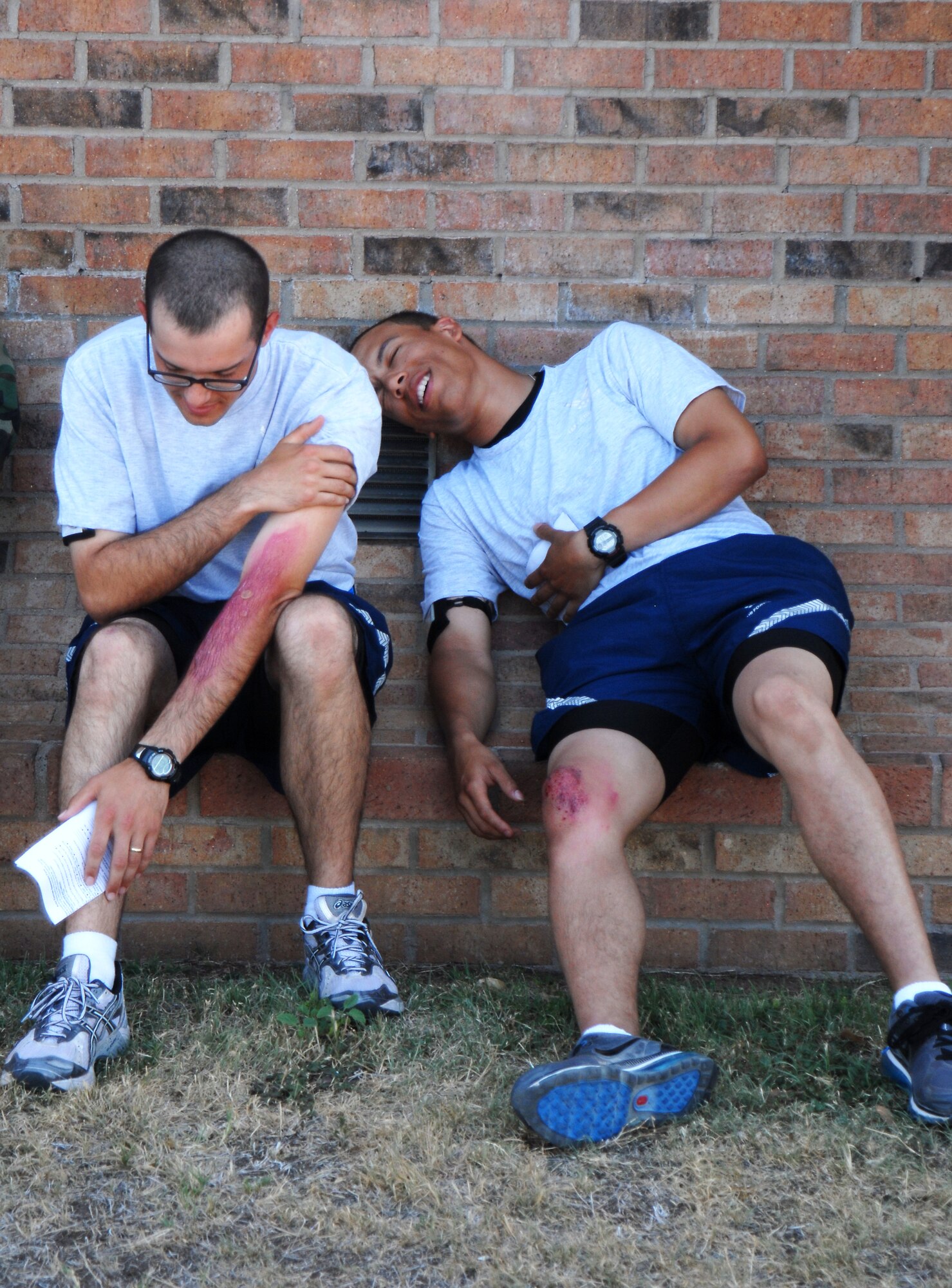 GOODFELLOW AIR FORCE BASE, TEXAS--Airman 1st Class Kevin Capps, 315th Training Squadron student, and Airman Basic Cameron Greene, 316th Training Squadron Student, wait to be treated for their chemical injuries during the exercise June 16. The scenario for the exercise was an unknown assailant tossed gas canisters into the theater contaminating those inside. (U.S. Air Force photo/Airman 1st Class Michael Smith)