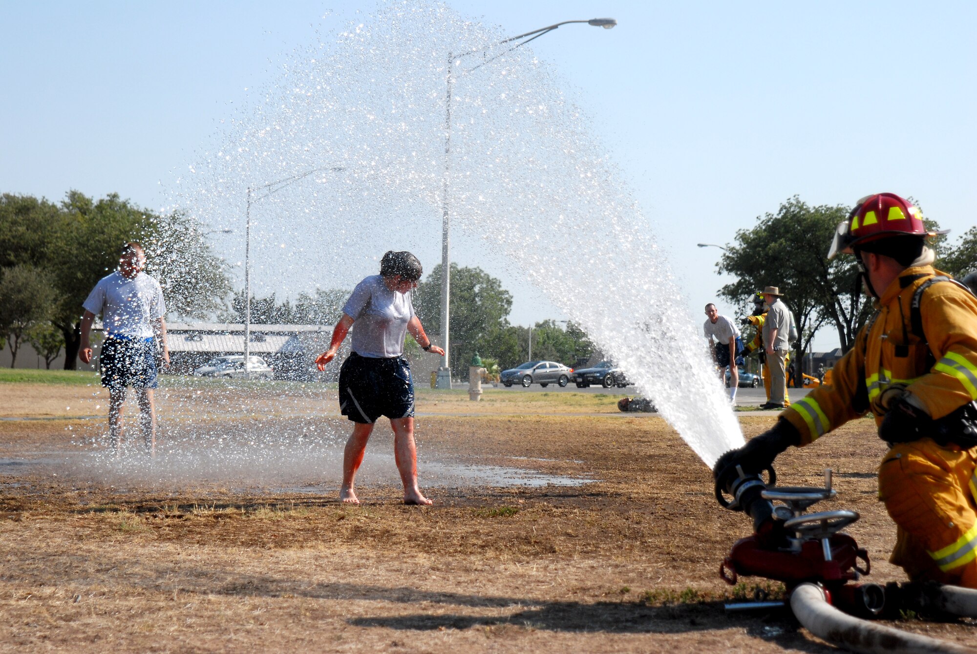 GOODFELLOW AIR FORCE BASE, TEXAS--Team Goodfellow firefighter decontaminates a 316th Training Squadron student with water during the exercise June 16. The scenario for the exercise was an unknown assailant tossed gas canisters into the theater contaminating those inside. (U.S. Air Force photo/Airman 1st Class Michael Smith)