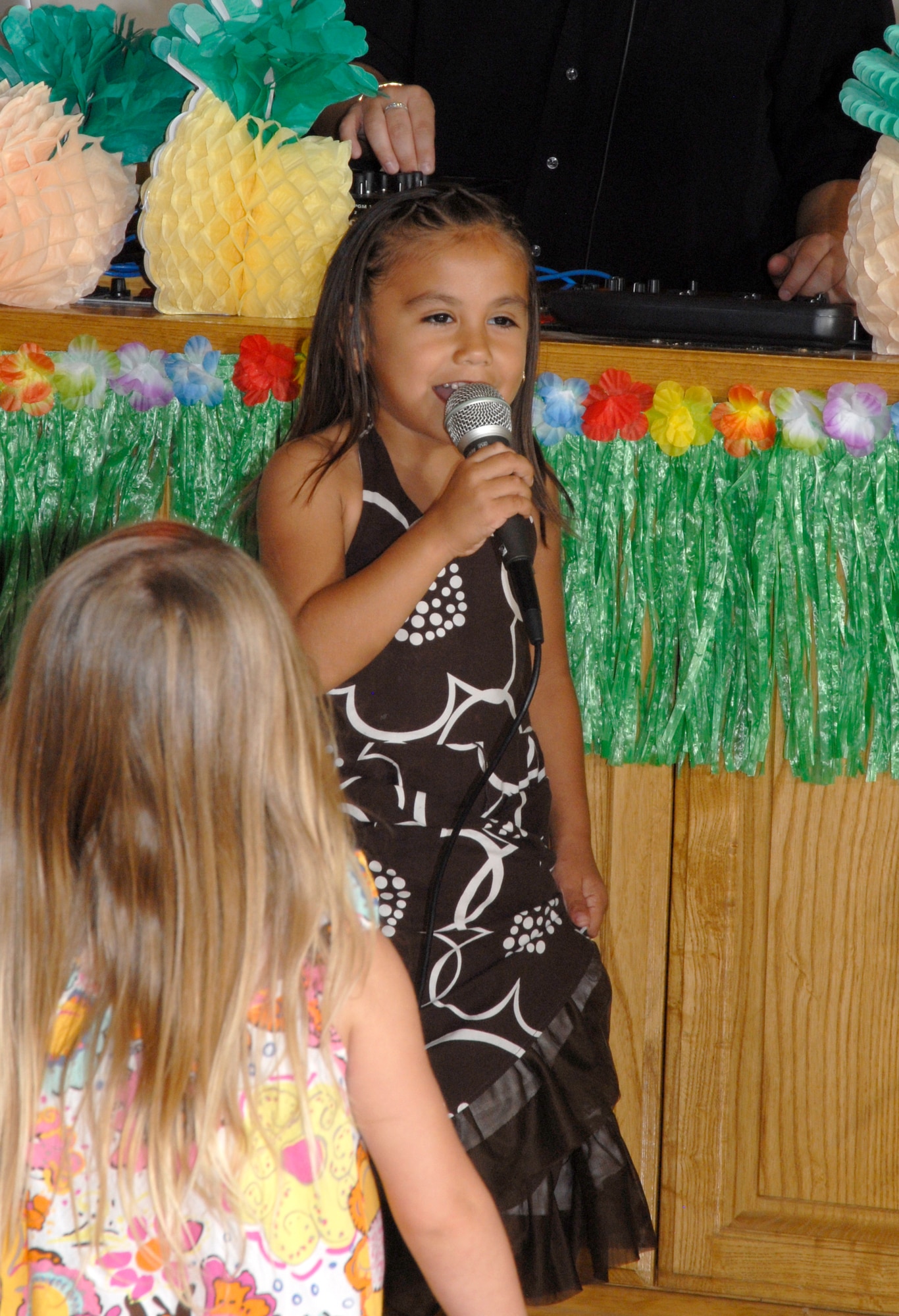 GOODFELLOW AIR FORCE BASE, Texas -- Six-year-old Gabriela Pena entertains the crowd during the Annual Daddy-Daughter Dinner and Dance at the Event Center June 16.  This year's theme was a Hawaiian Luau with almost 20 dad and daughter couples attending.  (U.S. Air Force photo/Connie Hempel)