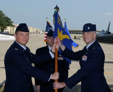 Col. Andrew Croft commander, 12th Operations Group hands the 560th Flying Training Squadron flag to Lt. Col Russell Driggers. Lt. Col Driggers assumed command of the 560th Flying Training Squadron during change of command ceremony at Randolph Air Force Base San Antonio, Texas, June 17.  ( U.S. Air Force Photo By Don Lindsey)