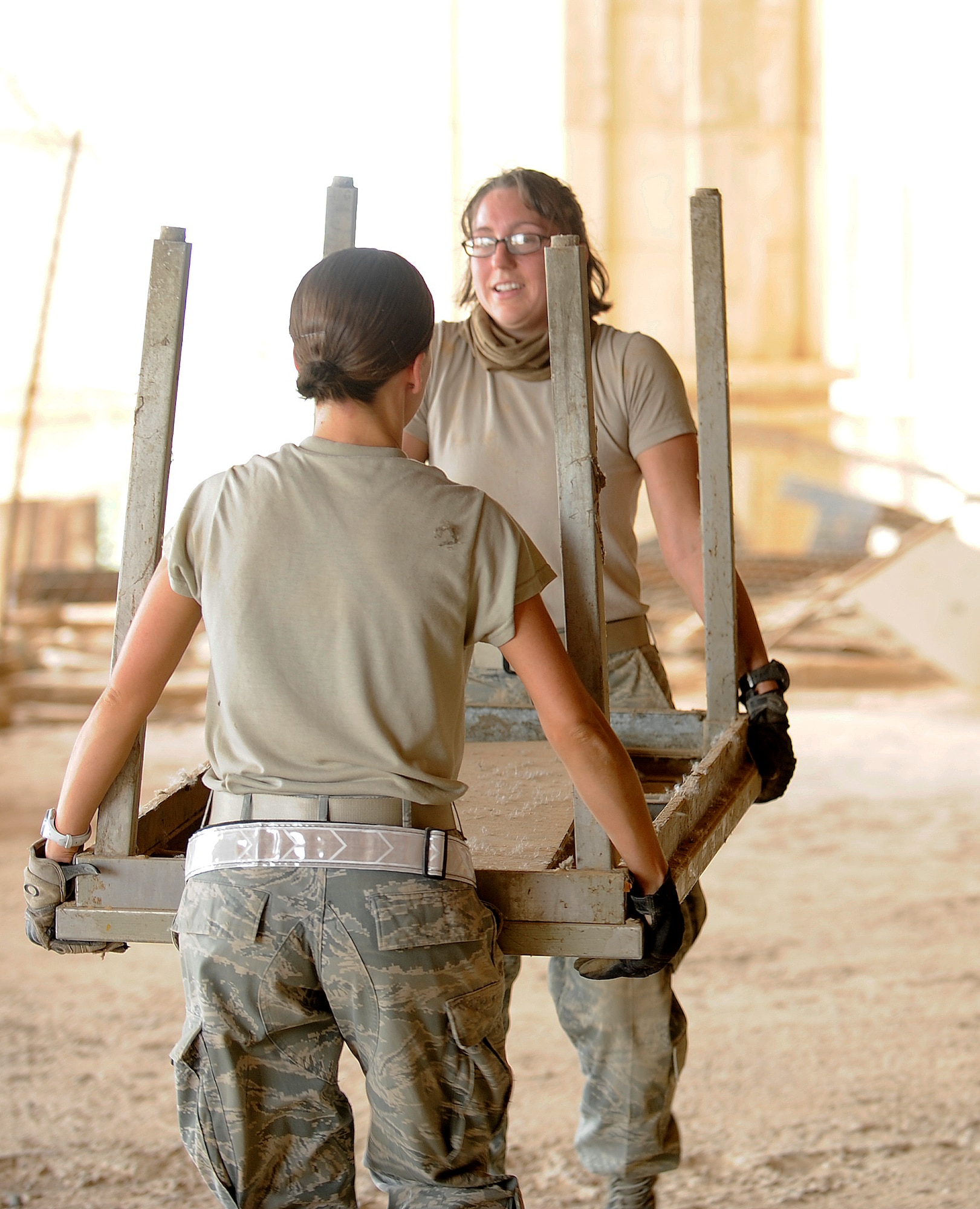 Staff Sgt. Alexis Johnson (left) and Staff Sgt. Nicole Beye, from the 447th Expeditionary Operations Support Squadron, remove debris from inside the Victory Over America Palace as more than 35 volunteers cleaned up the palace June 11, 2011, at Camp Slayer outside Baghdad, Iraq.  (U.S. Air Force photo/Tech. Sgt. Jason Lake)