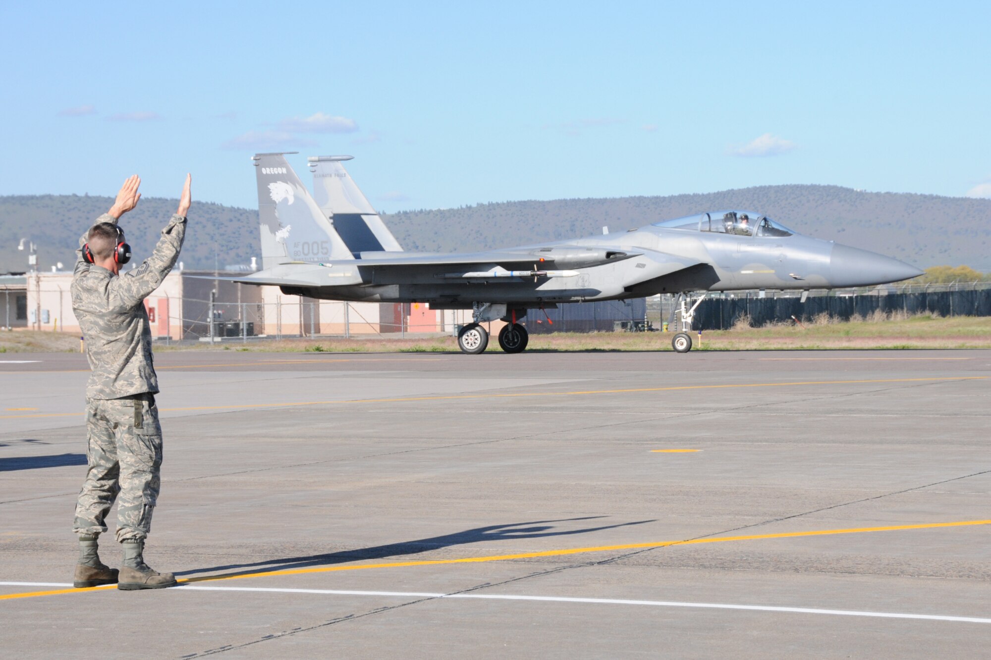 Master Sgt. Sean Campbell, 173rd Fighter Wing F-15 crew chief, signals Lt. Col. Wes "Pappy" French, 173rd Fighter Wing Chief of Safety, in after French's 3,000 hour flight June 8, 2011 at Kingsley Field, Klamath Falls, Ore.  (U.S. Air Force Photo by Tech. Sgt Jennifer Shirar) RELEASED
