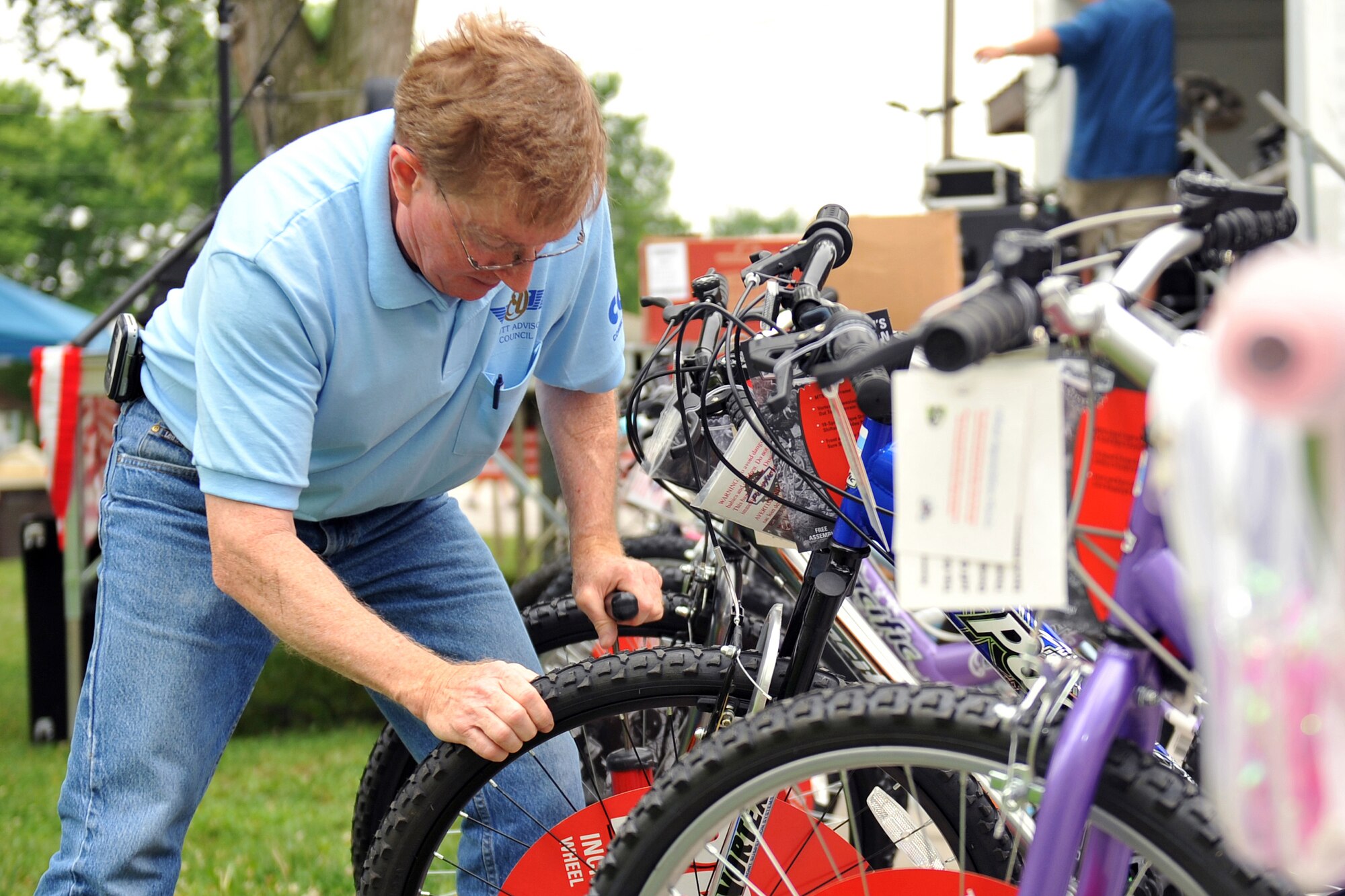 Lyle Ward, member of the Offutt Advisory Council, checks the air in all the bikes that will be given away during the OACs Annual Offutt Appreciation Picnic June 10, 2011 at the Offutt Air Force Base, Neb., Base Lake. Team Offutt employees and their families enjoyed a day in the sun that included free food, beverages and entertainment during the event. (U.S. Air Force photo by Jeff W. Gates/Released)
