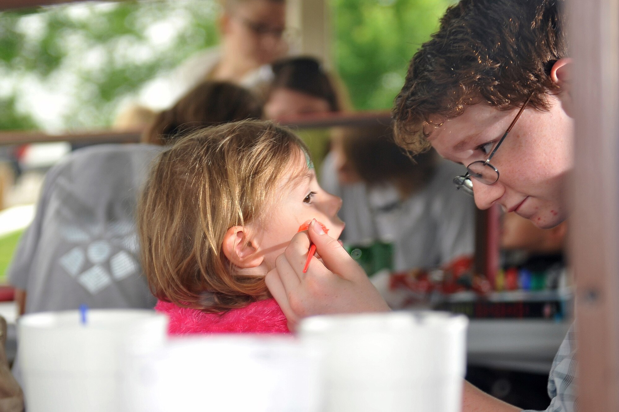 Nate James, son of David James, a civilian working for U.S. Strategic Command, carefully paints his sister's face, Grace, at the Offutt Advisory Council's Annual Offutt Appreciation Picnic June 10, 2011 at the Offutt Air Force Base, Neb., Base Lake. Team Offutt employees and their families enjoyed a day in the sun that included free food, beverages and entertainment during the event. (U.S. Air Force photo by Jeff W. Gates/Released)