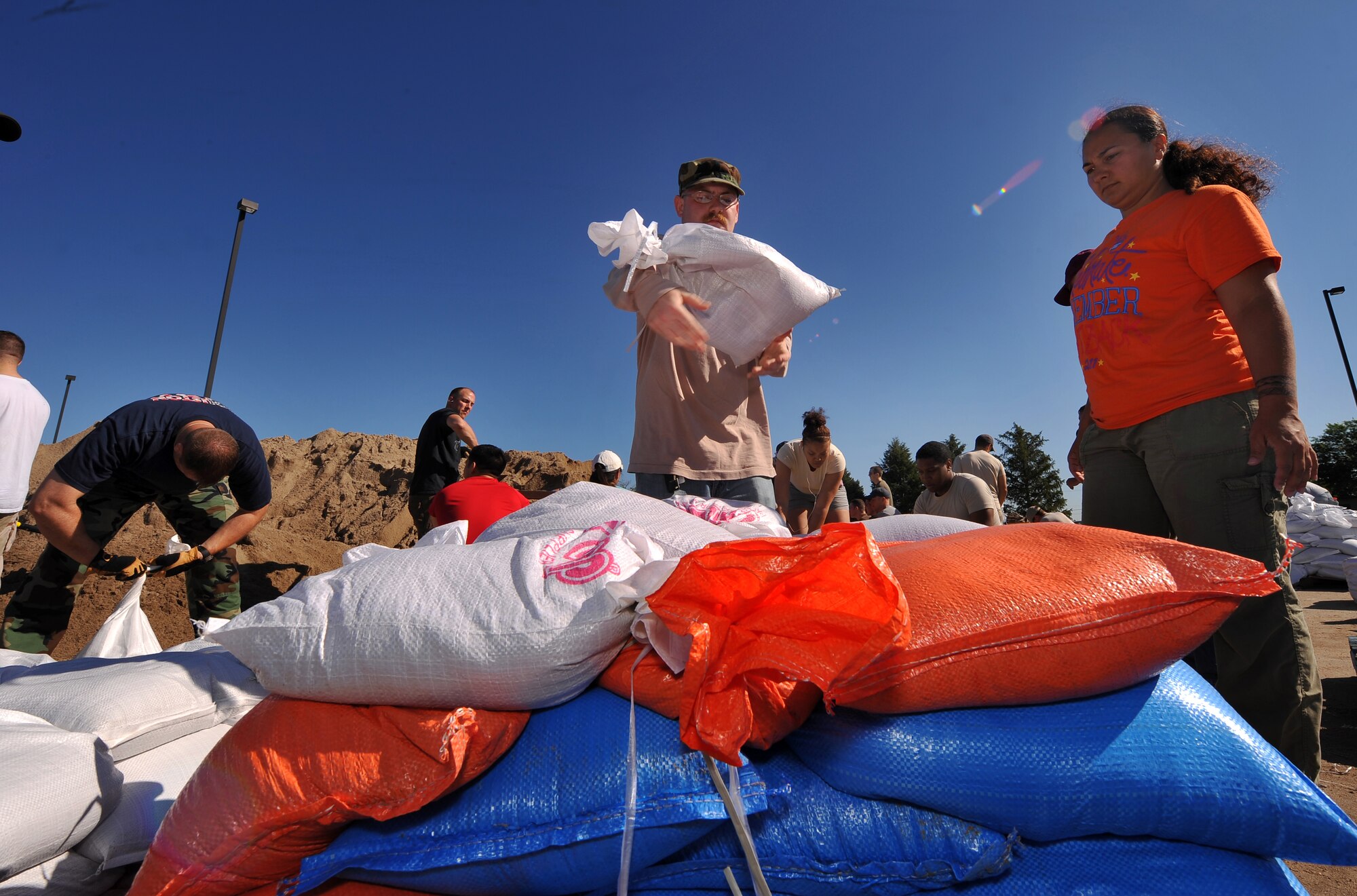 U.S. Air Force Staff Sgt. Keith Hilliard from the 97th Intelligence Squadron tosses another sand bag onto the pile at Offutt Air Force Base, Neb., June 15, 2011. Volunteers from Team Offutt are filling sand bags to build walls around structures that could be affected by the Missouri River floodwaters if the levee were to fail. (U.S. Air Force photo by Josh Plueger/Released)