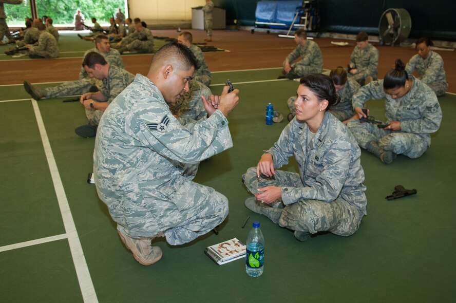 HANSCOM AIR FORCE BASE, Mass. – Senior Airman Alex Perez (left), 66th Security Forces Squadron, gives weapons familiarization instruction to 1st Lt. Danielle Reese during the operational readiness inspection preparation event at the Tennis Bubble June 10. In addition to weapons familiarization by security forces, members of the 66th Medical Squadron presented self-aid and buddy care to prepare Airmen for a potential fall ORI. (U.S. Air Force photo by Rick Berry)